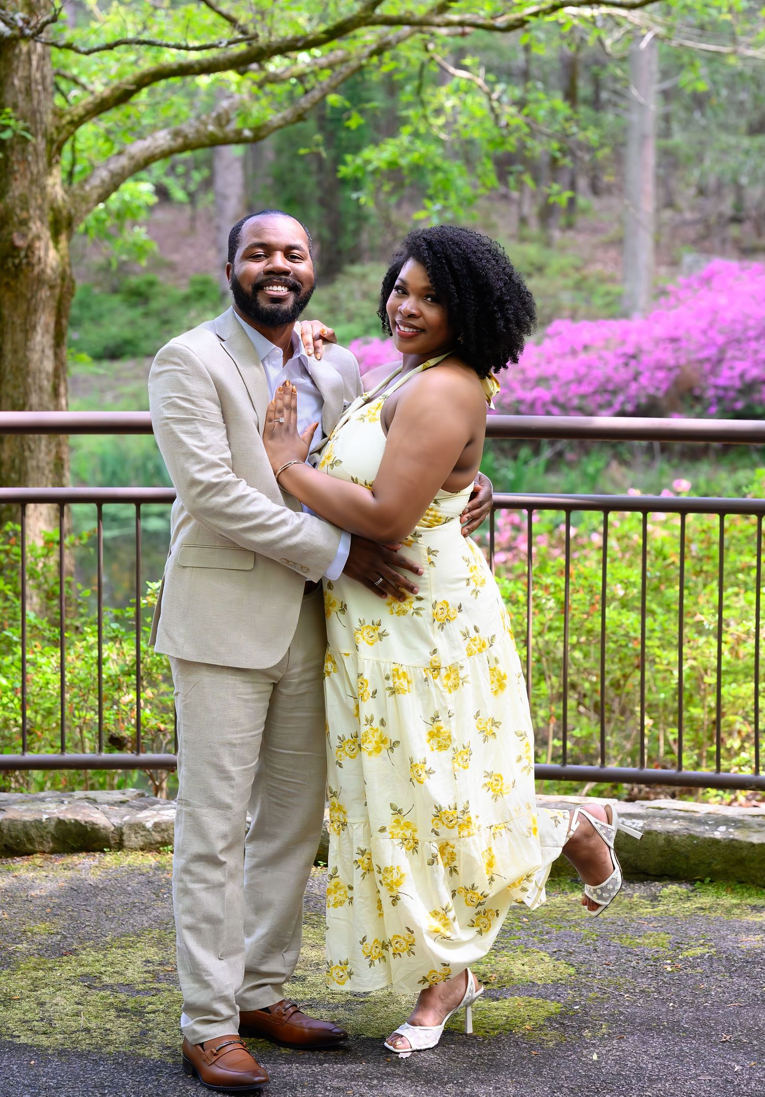 Happy couple embracing and smiling in a lush garden with blooming azaleas.