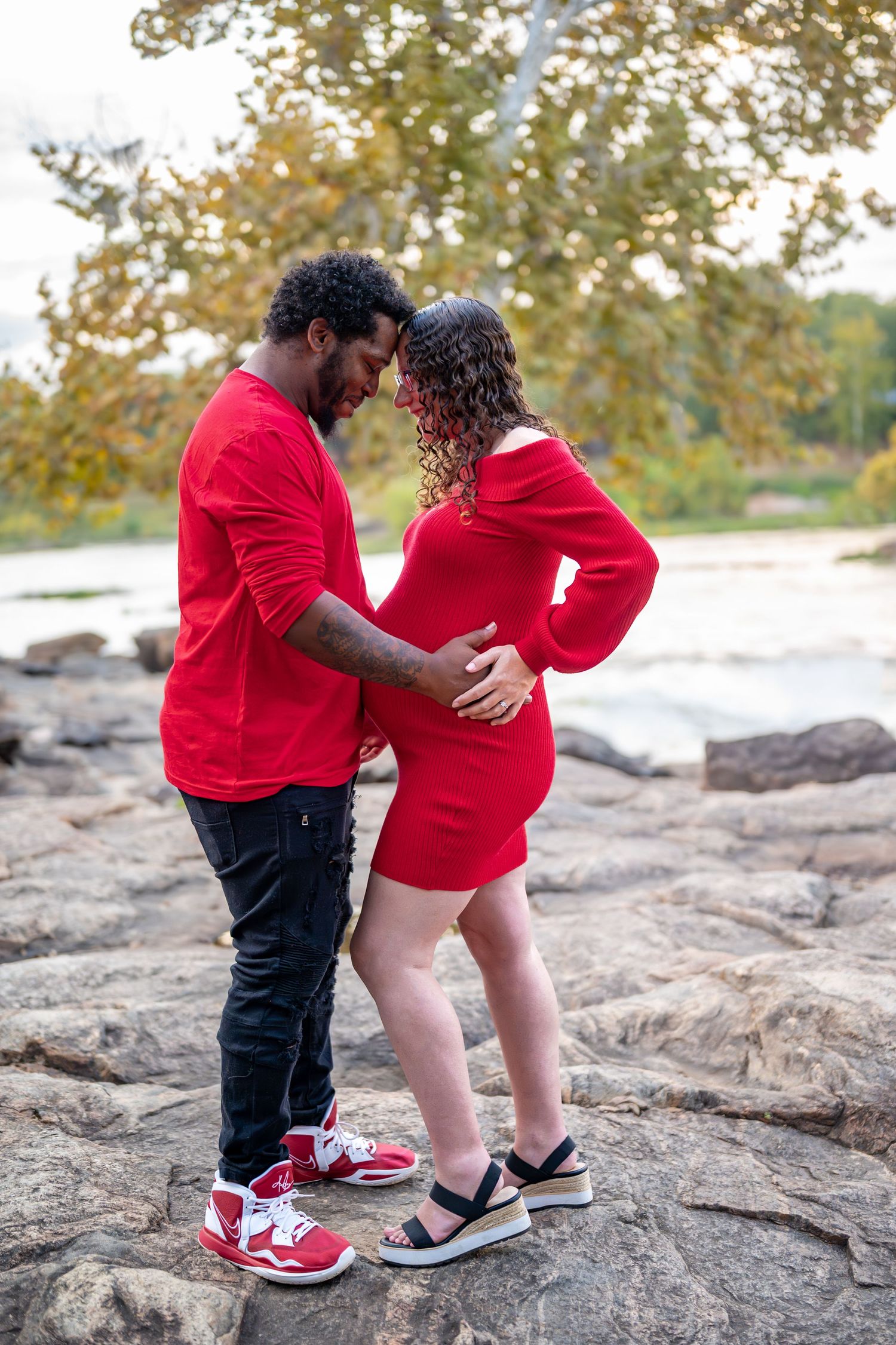 Two pairs of shoes visible as a couple stands together on rocky terrain.