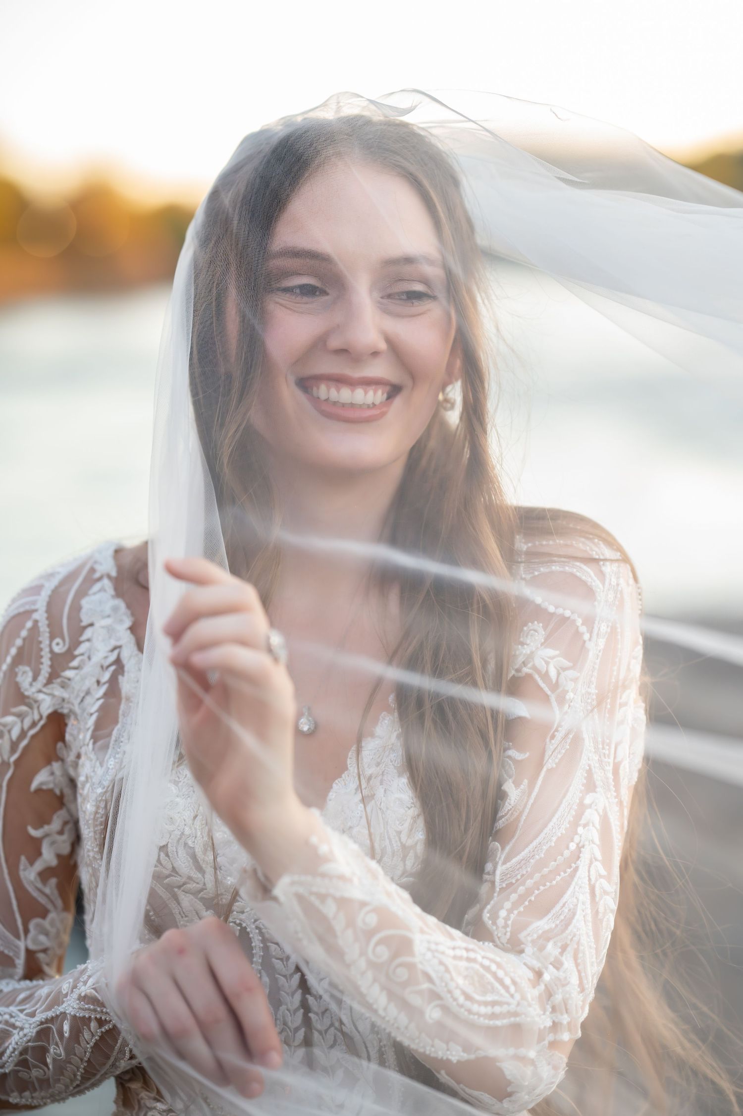 Candid bridal portraits with soft veil details in warm evening light.