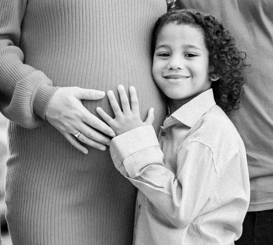 A black and white photo series showing a child in a white shirt playfully interacting with someone off camera.