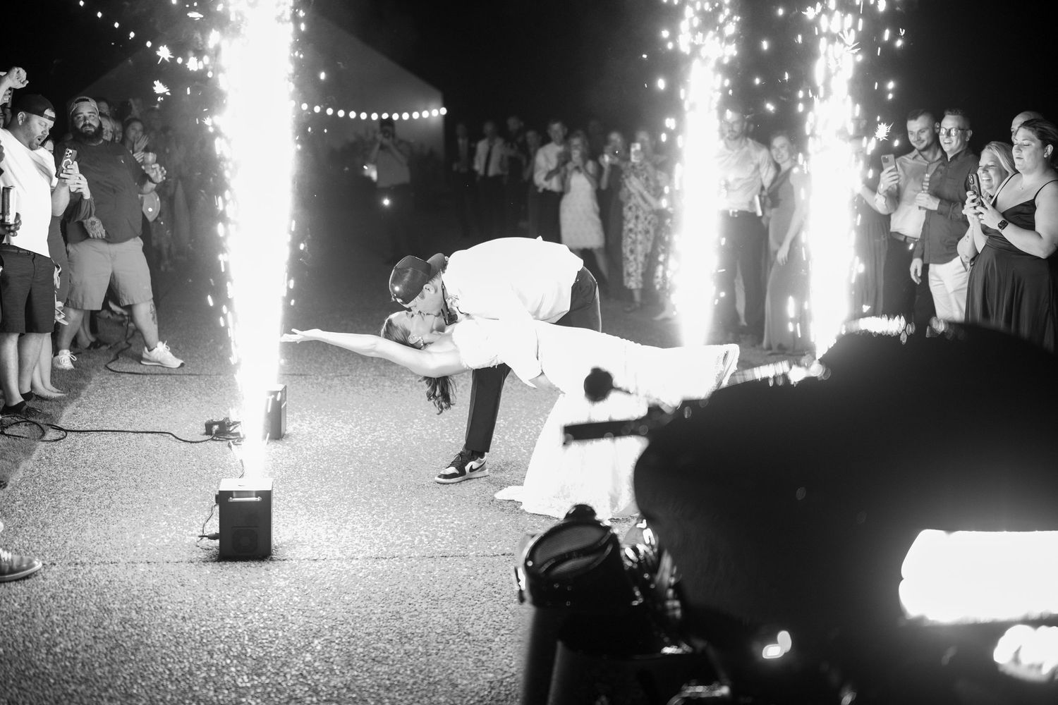Dramatic black and white photo of wedding couple's final dance with sparkler effects.