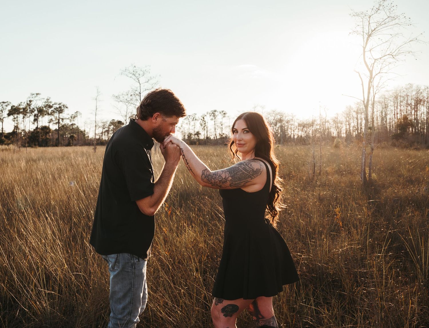 Romantic couple photoshoot in a golden field during sunset.