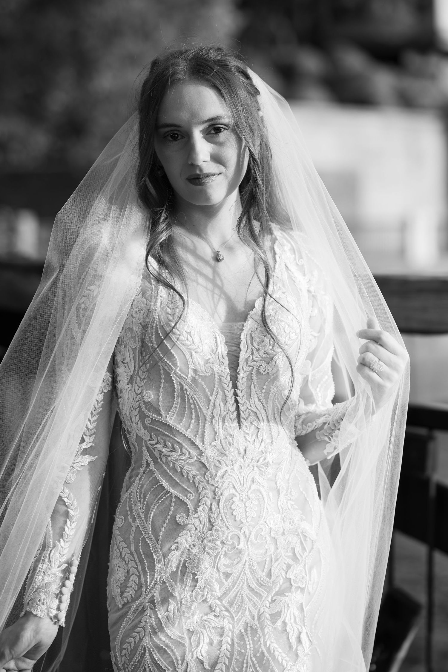 Black and white bridal portraits showing intricate lace details and flowing veil in natural light.