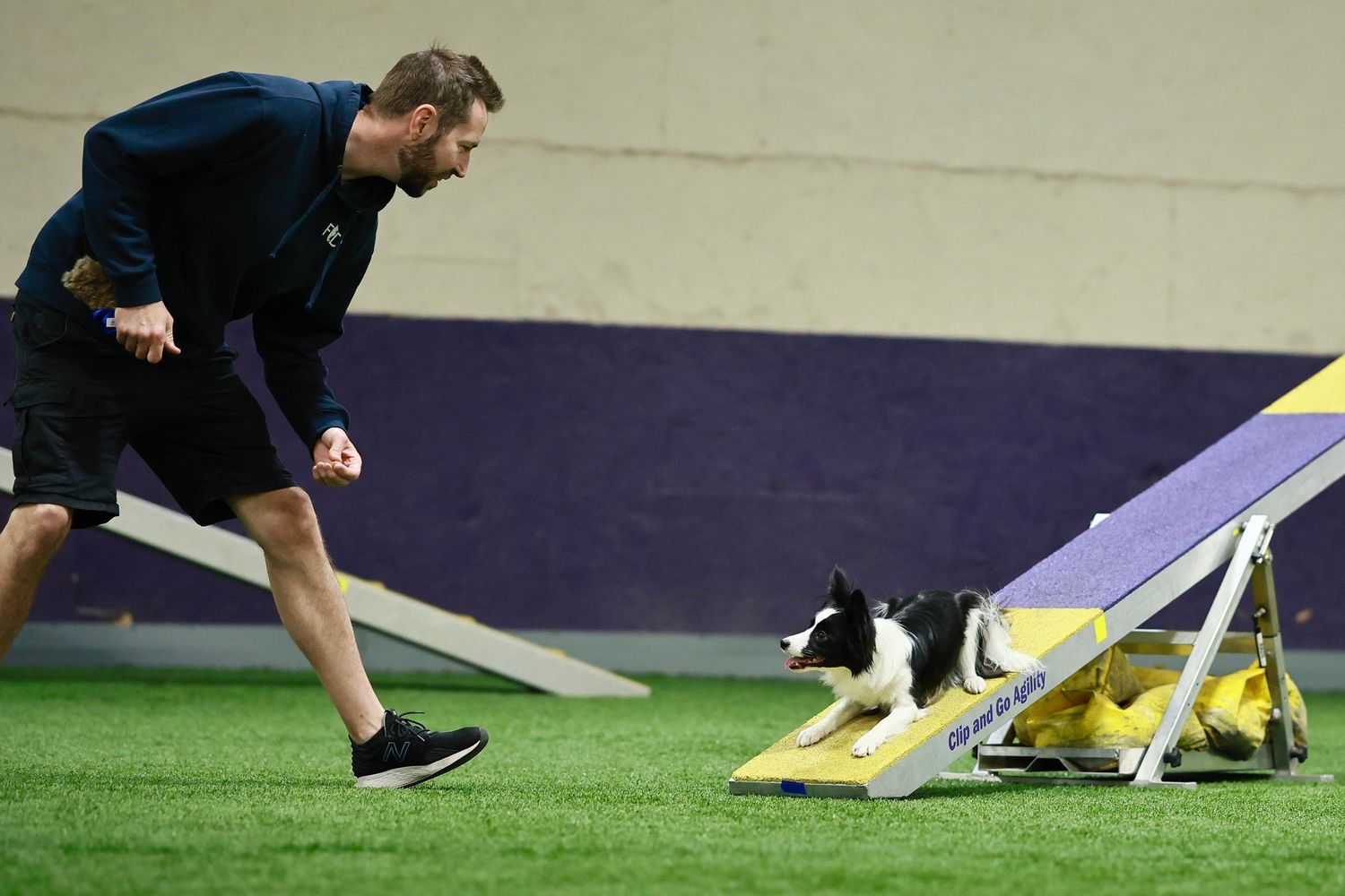Athletes perform speed and agility drills on a sports field using yellow training markers and cones.