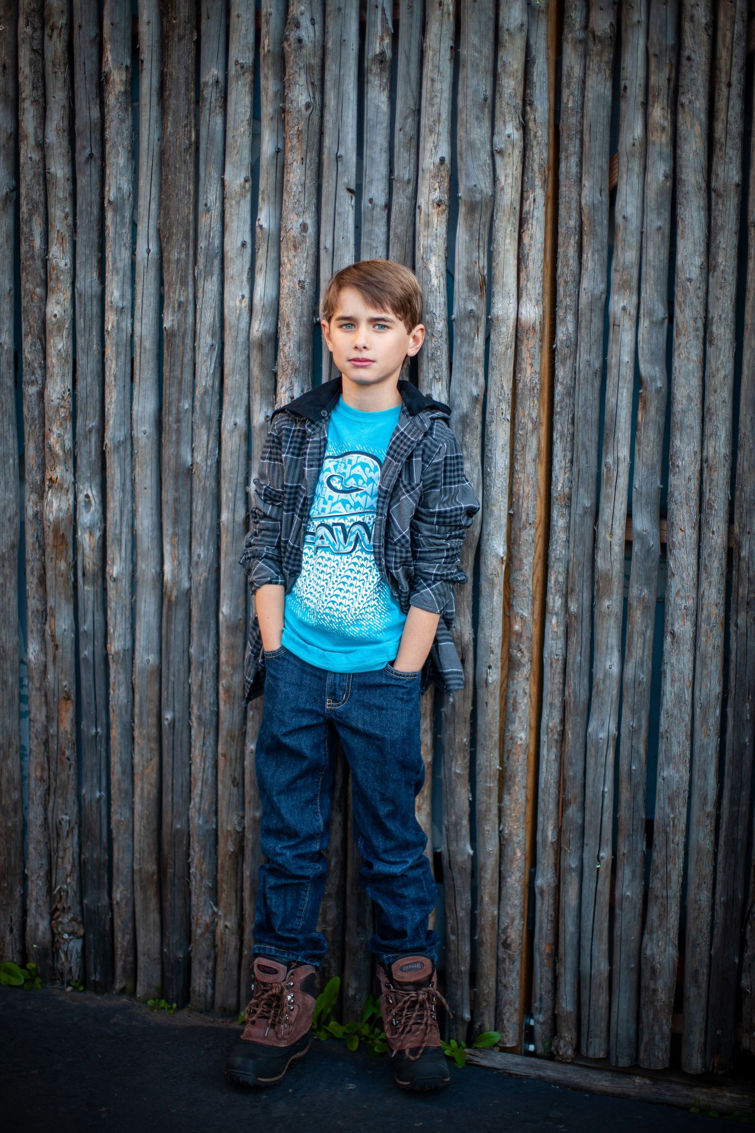 A triptych of images showing a youth in a blue t-shirt and denim against a rustic wooden fence background.