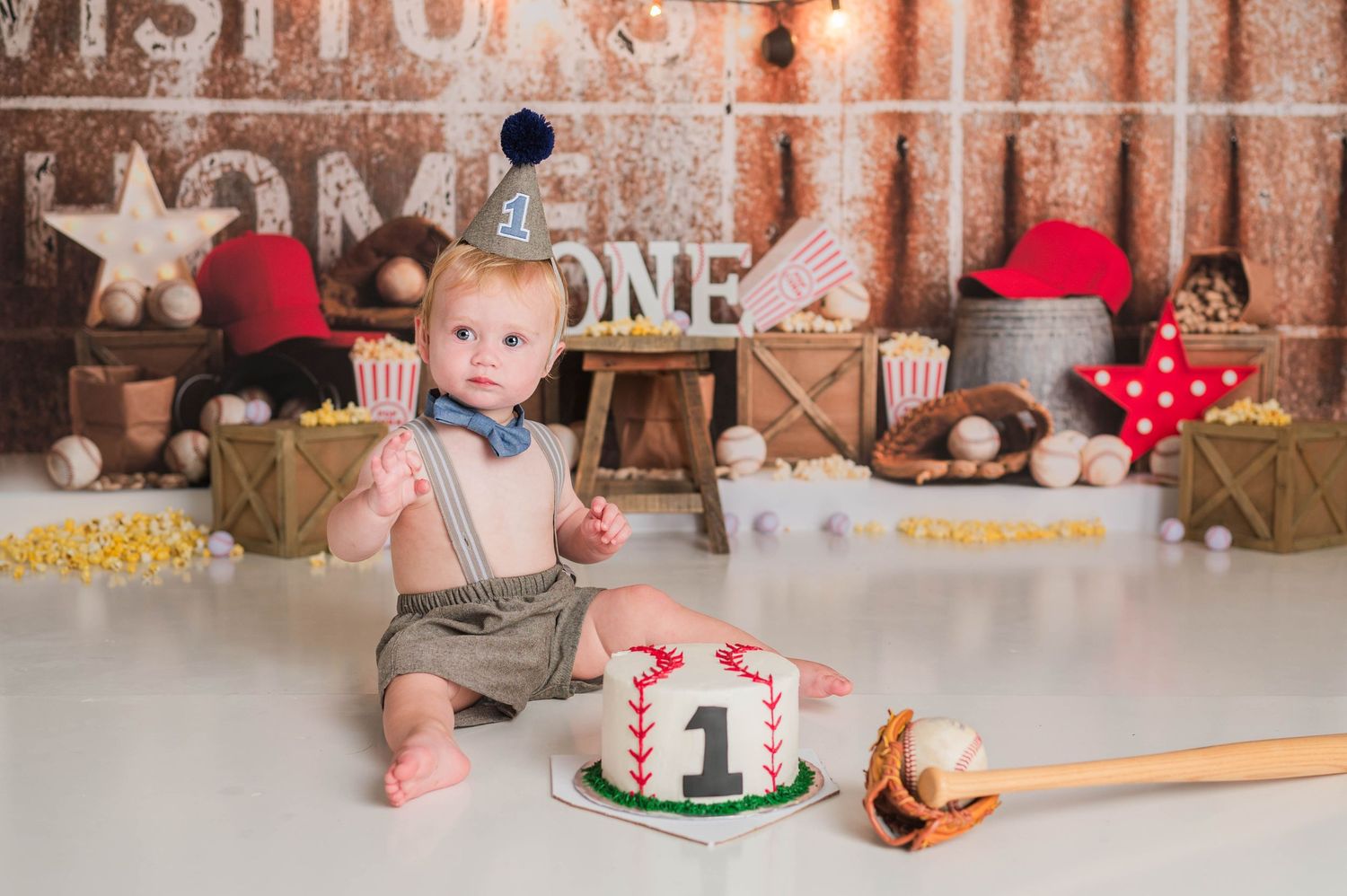 First birthday cake smash photo session with rustic woodland theme and string lights.