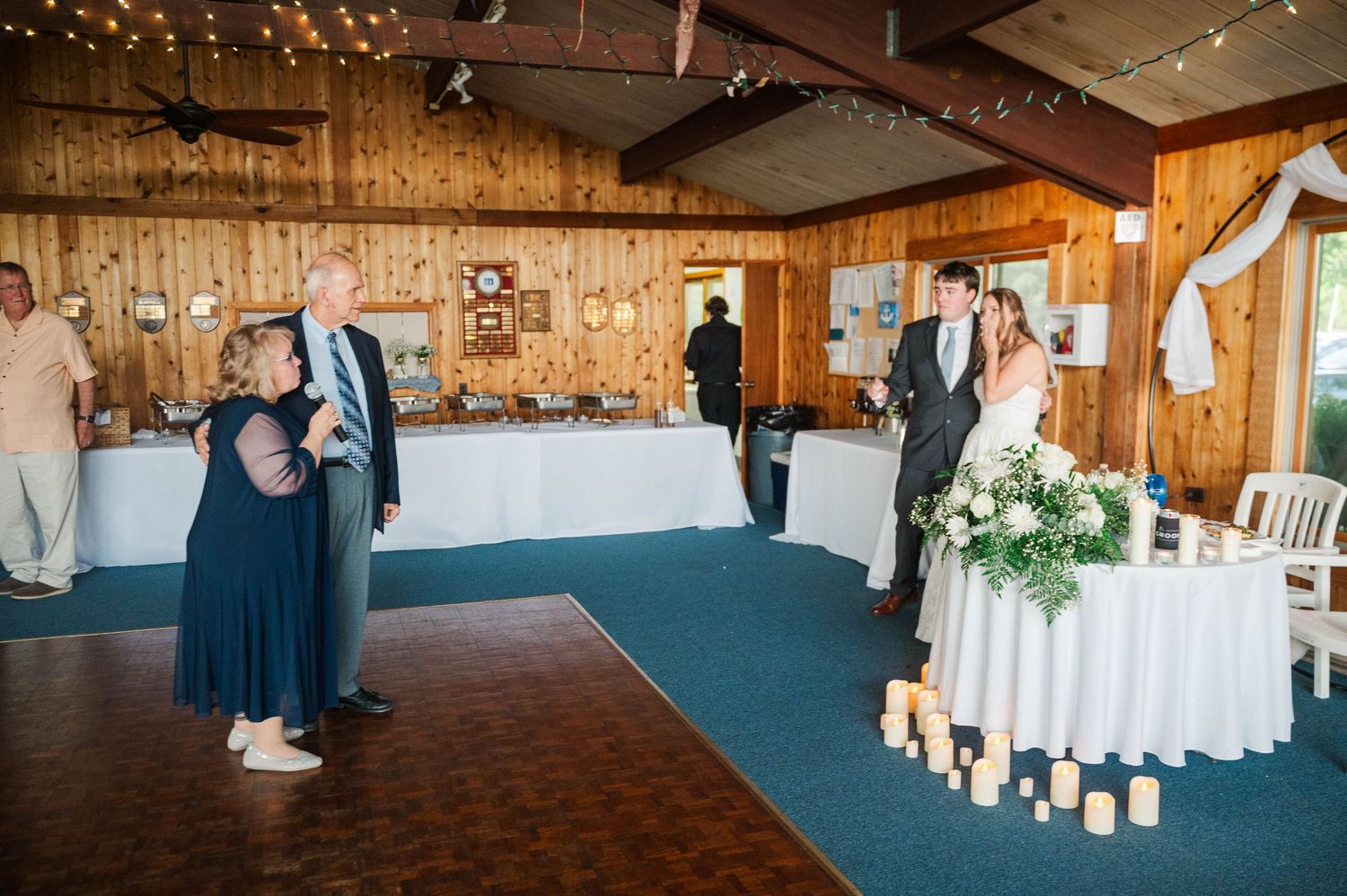 Rustic barn wedding venue decorated with string lights and white drapery.