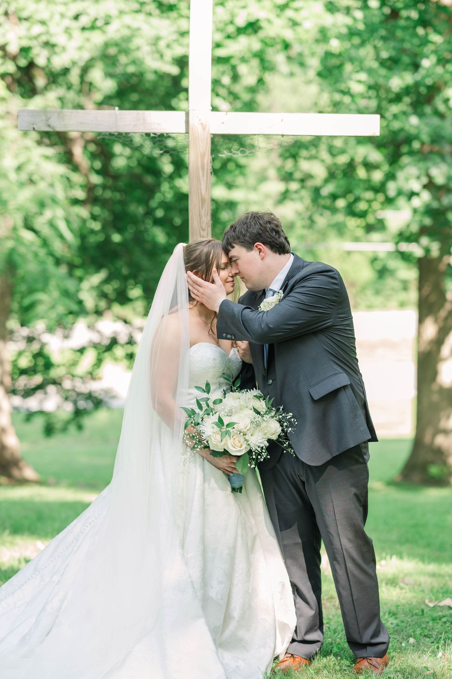 Romantic wedding portraits in a lush garden setting with flowing veil.