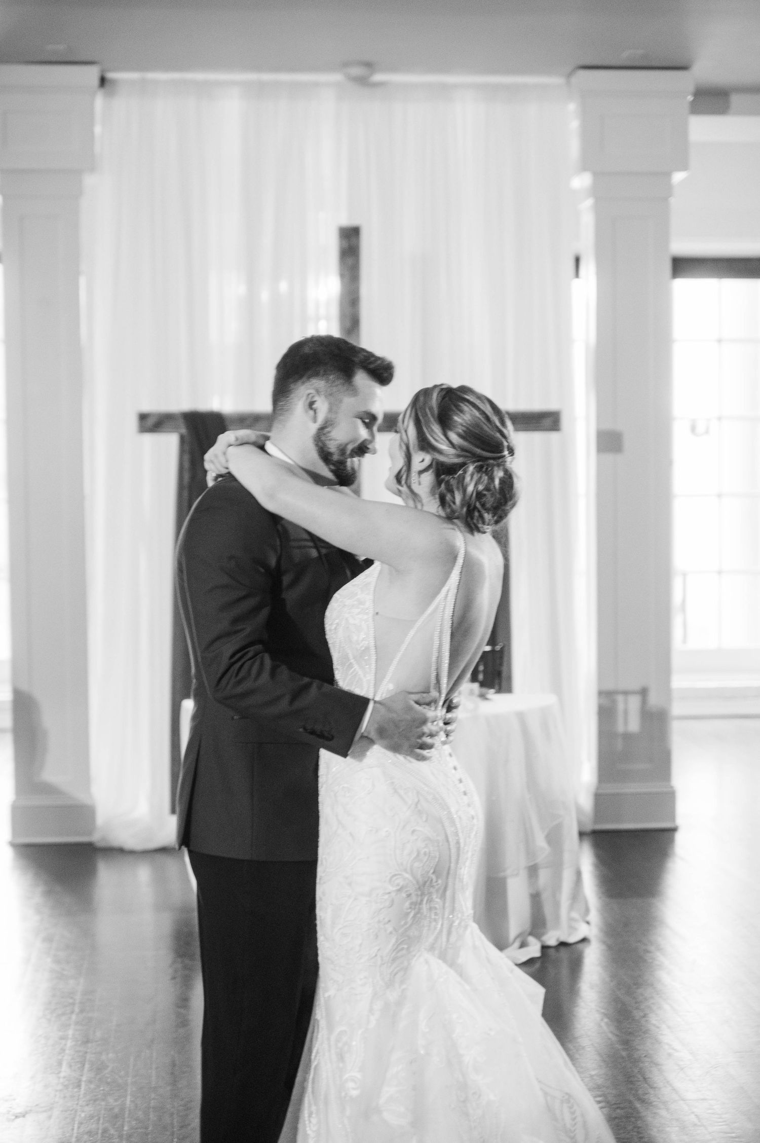 Black and white wedding dance photos showing couple's first dance in elegant ballroom.