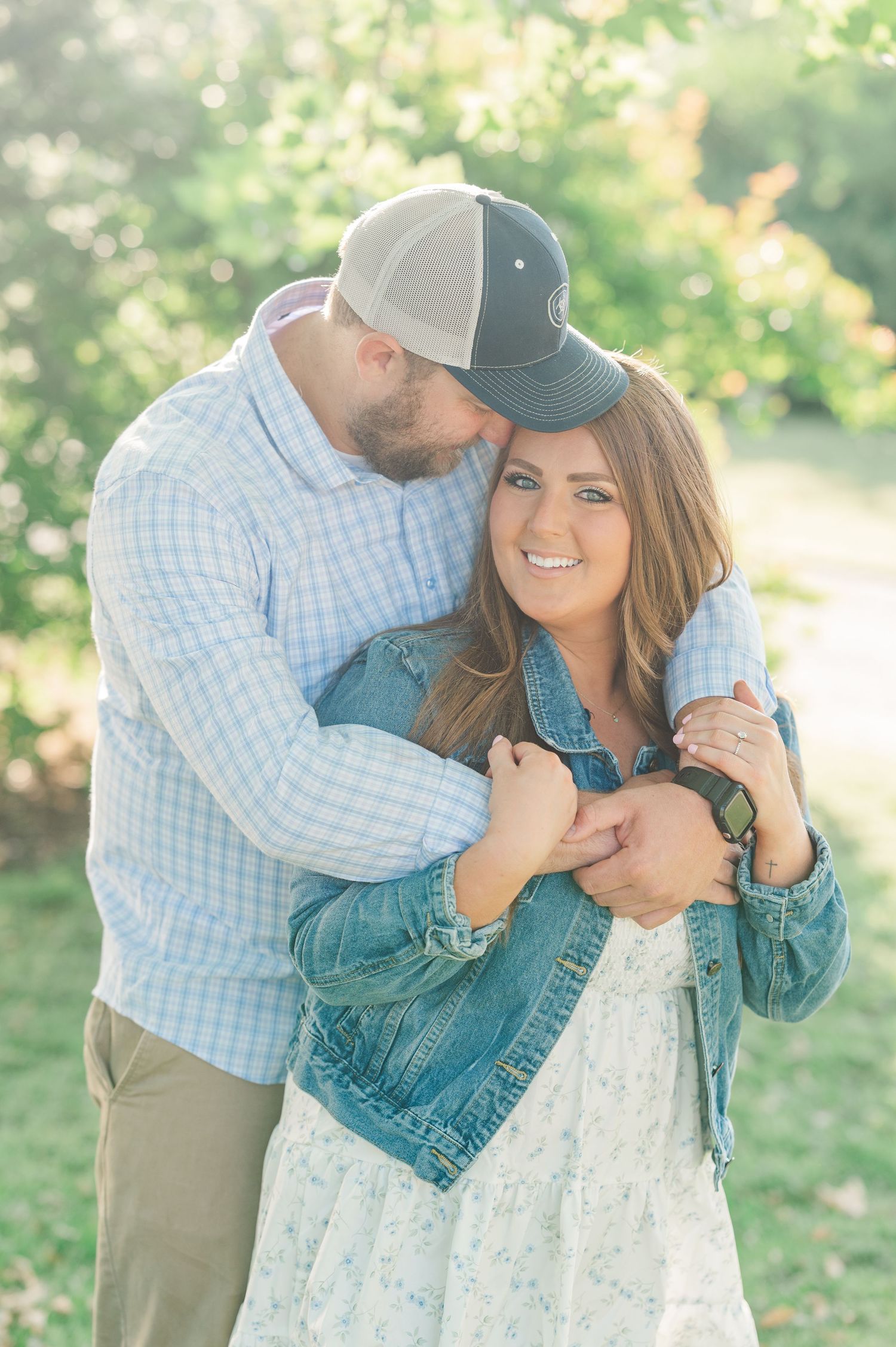 Couple sharing romantic moments in a sunlit garden setting.