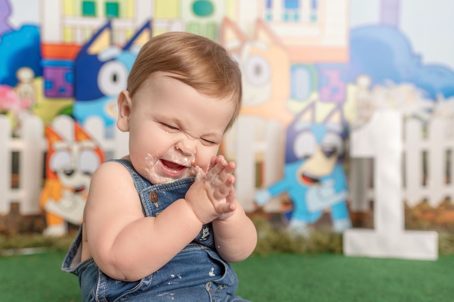 First birthday cake smash session with blue overalls with Bluey backdrop