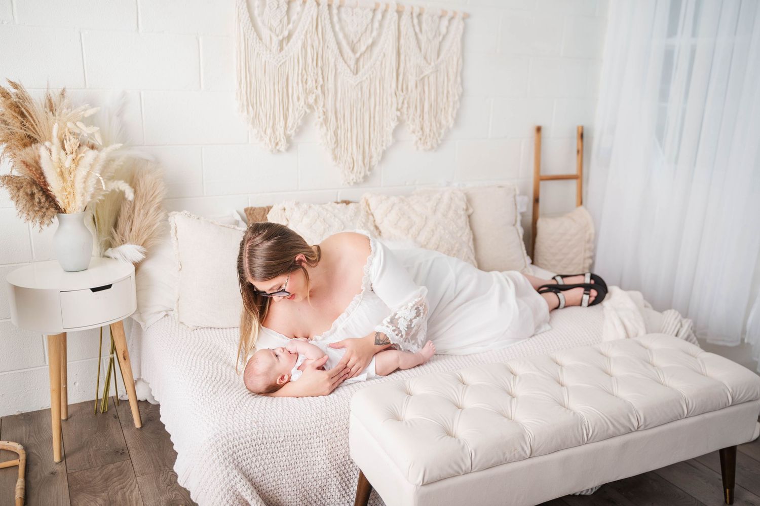 Dreamy newborn photo session with macrame wall hangings and neutral tones.