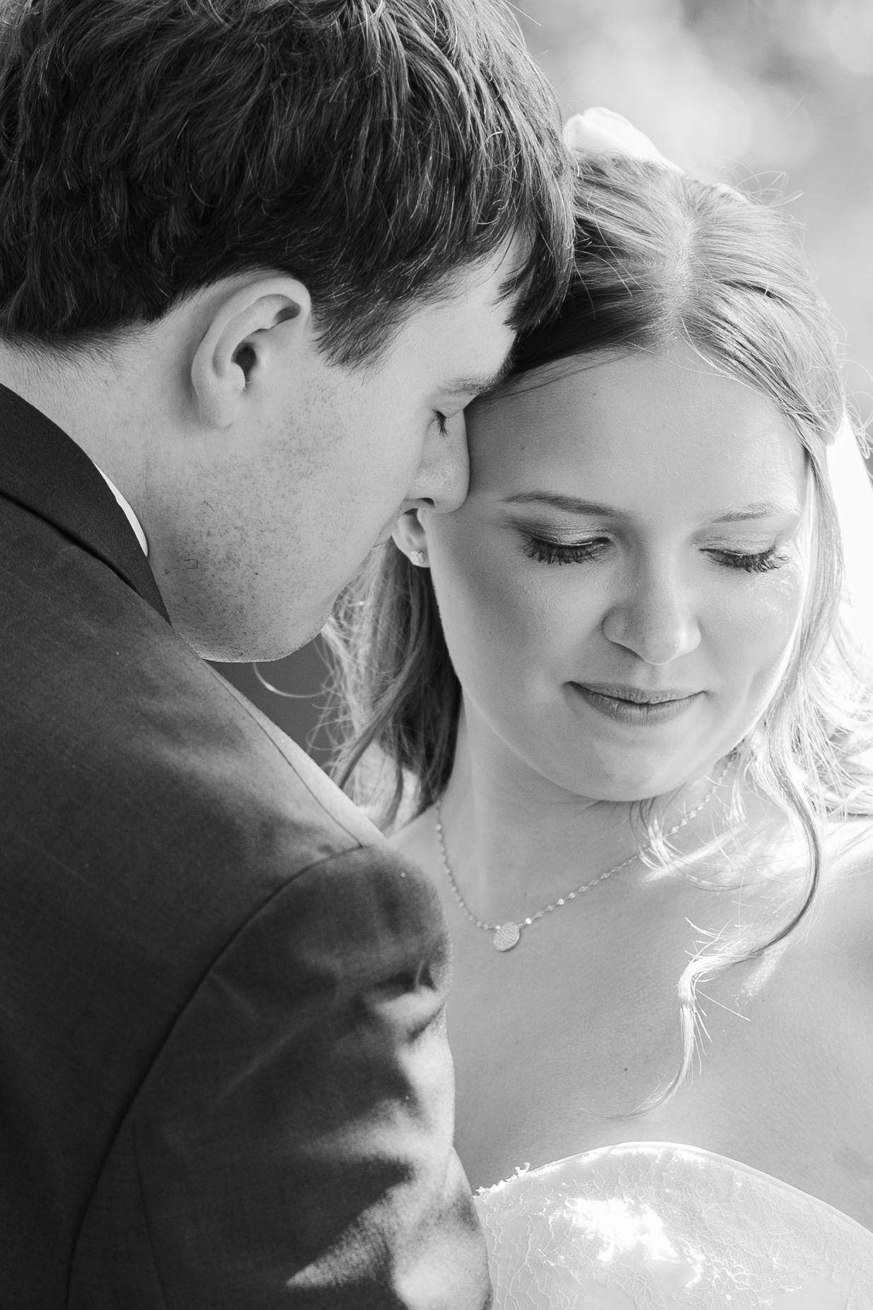 Black and white intimate wedding portrait with soft natural lighting.