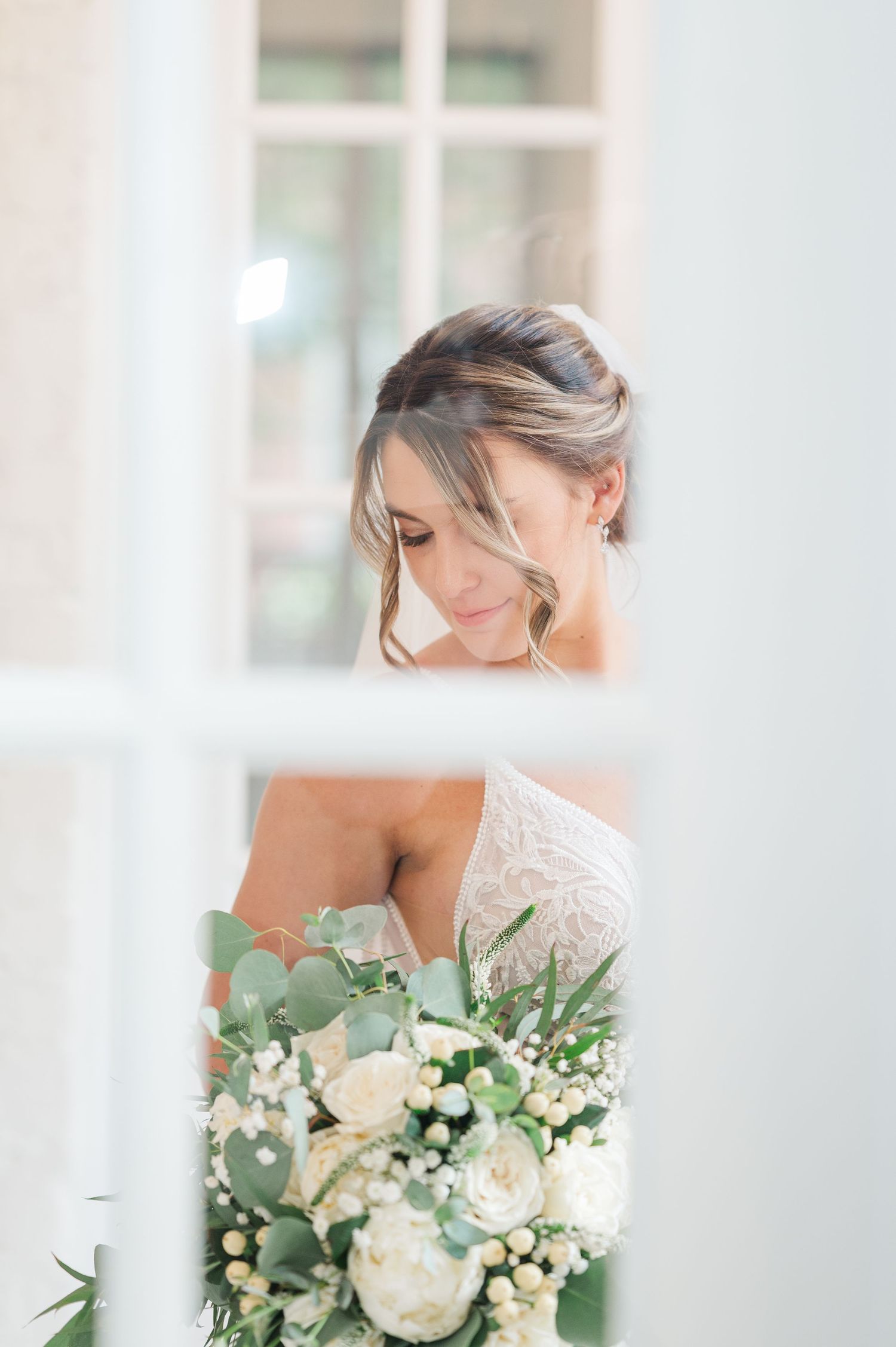 Elegant bridal portraits featuring white floral bouquet with roses and greenery.