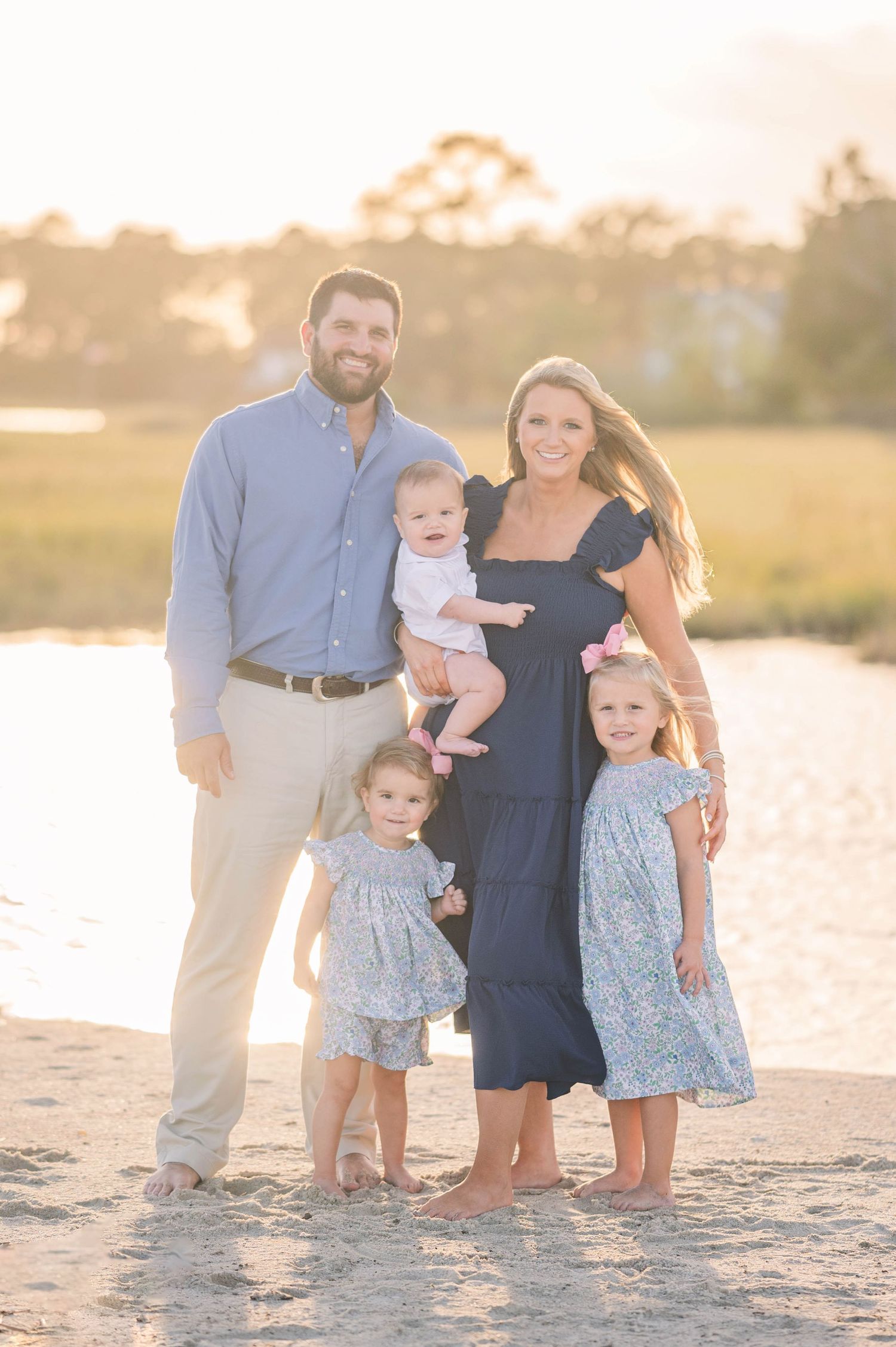 Family of five posing on a sandy beach at golden hour. Mathews, Virginia.