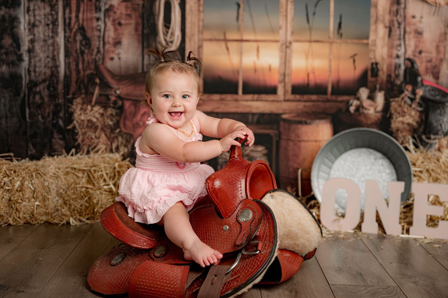 Cowgirl cake smash. Little girl on horse saddle in studio.