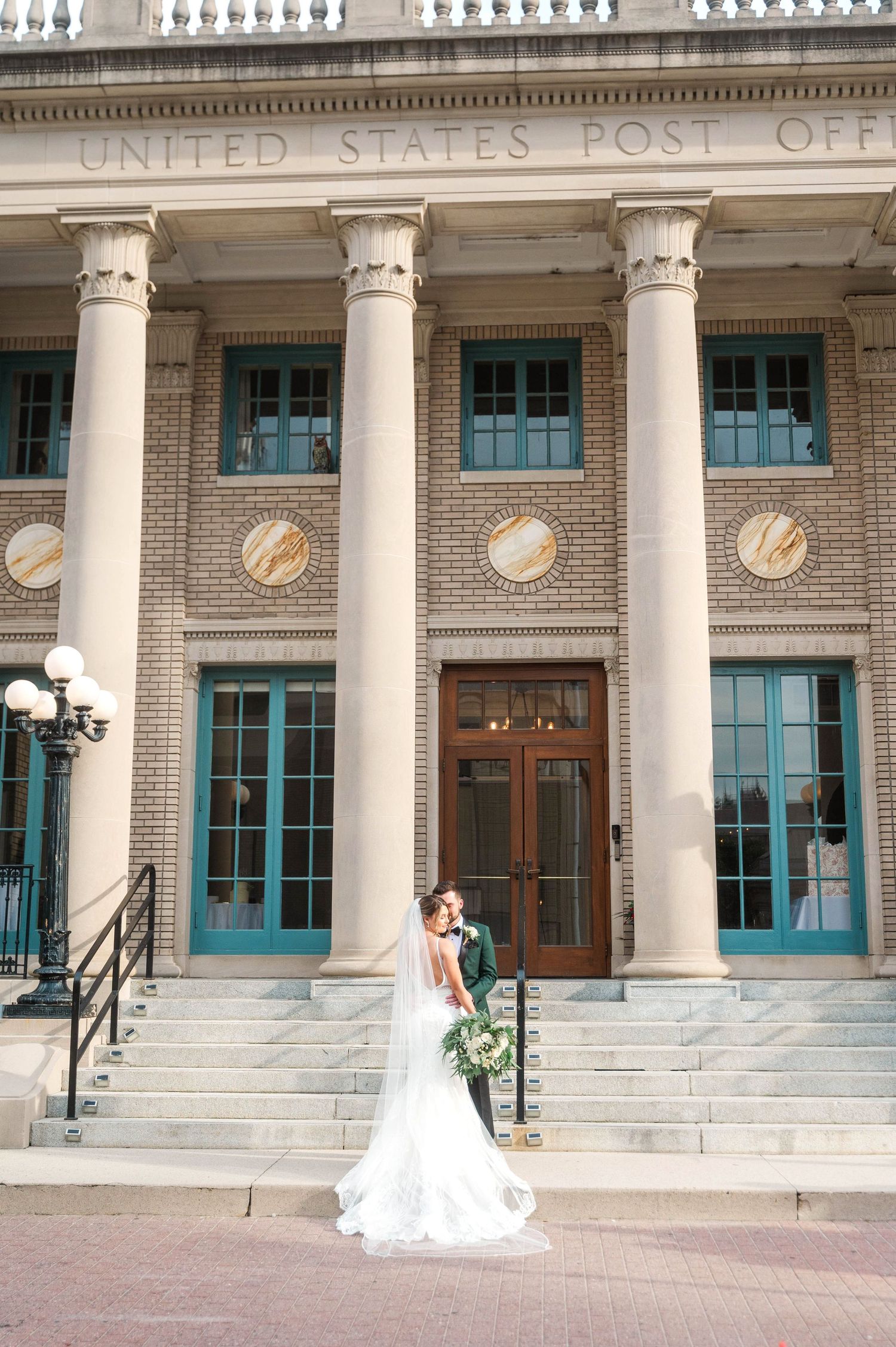 Wedding portrait at historic United States Post Office building with grand columns.