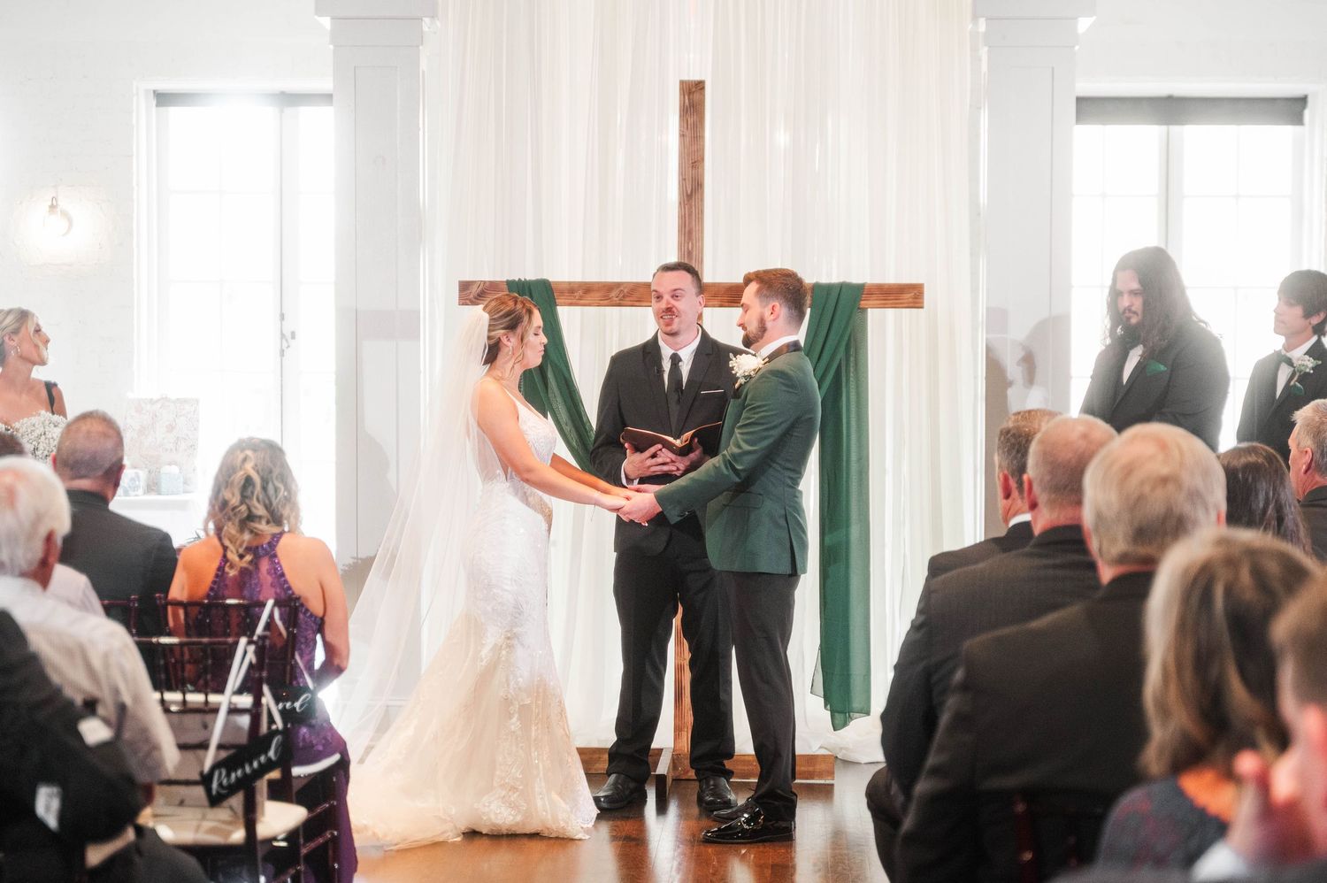 Wedding ceremony attendees seated in rows during an indoor service.