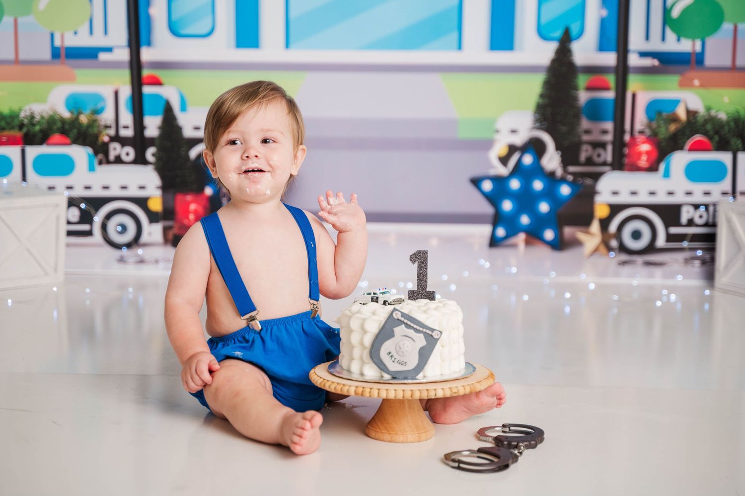 Baby's first birthday photo session with transportation theme and toy trucks.