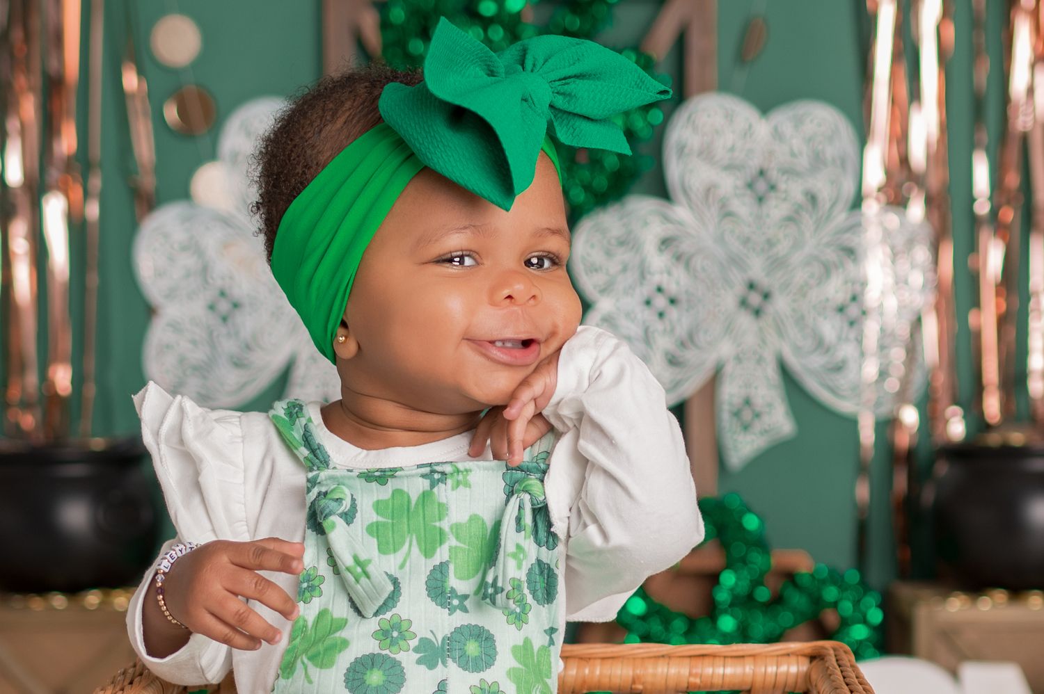 Festive St. Patrick's Day themed portrait with green headwrap, shamrock decorations and white outfit.