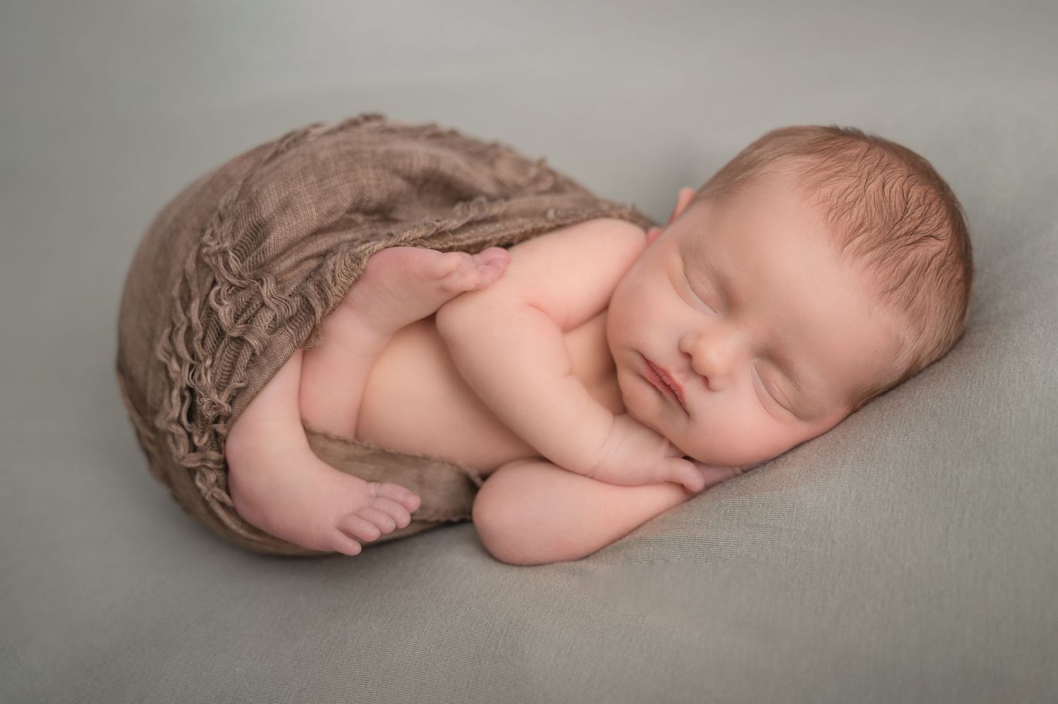 newborn baby in studio wrap.