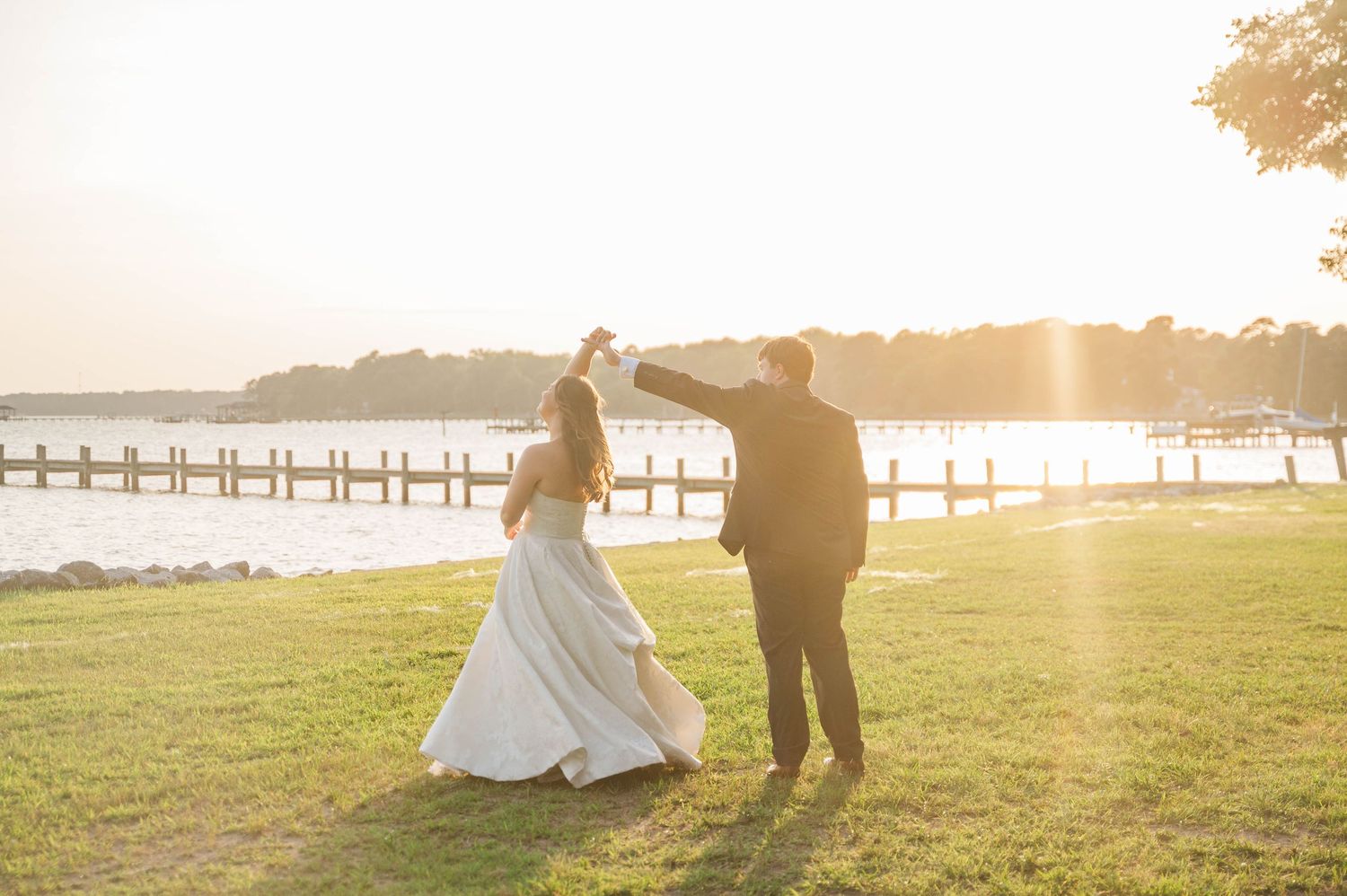 Silhouette of couple walking along waterfront during golden hour sunset.