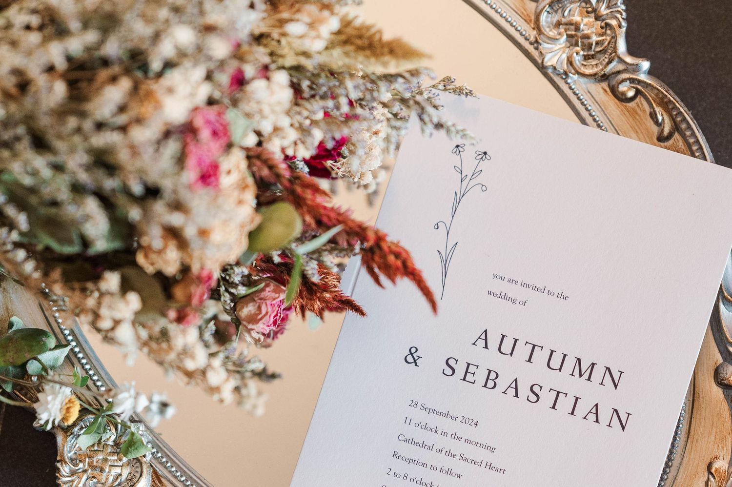 Wedding invitation suite with autumn-themed floral details and calligraphy.