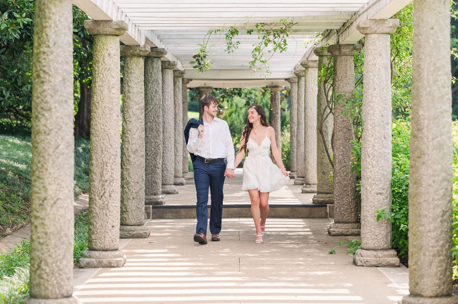 Stone colonnade walkway with greenery creating a romantic garden setting. Maymont. Engagement
