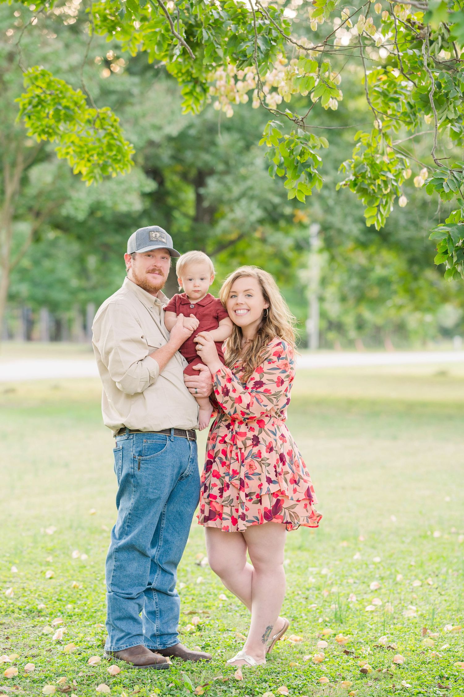 Family enjoying a playful moment together in a sunny green park with scattered wildflowers.