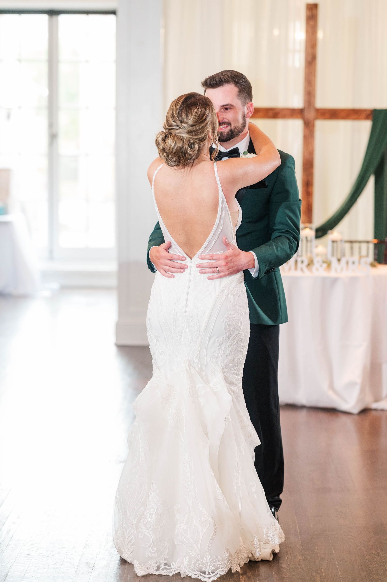 Wedding couple sharing intimate first look moment in bright indoor venue.