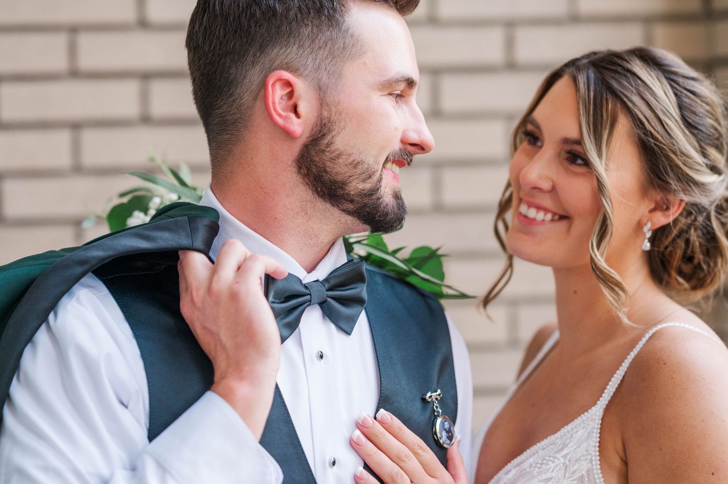 An intimate wedding portrait series showing tender moments against a brick backdrop.