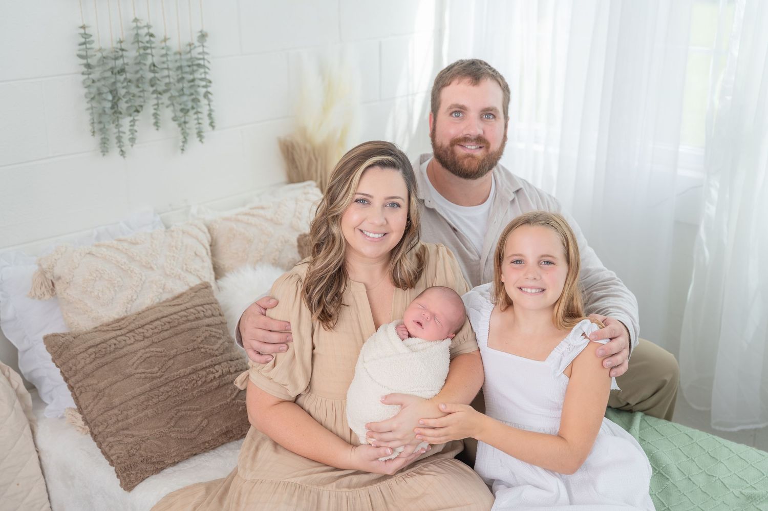 Family newborn studio. Moments between parents and newborn in a bright, cozy home setting.