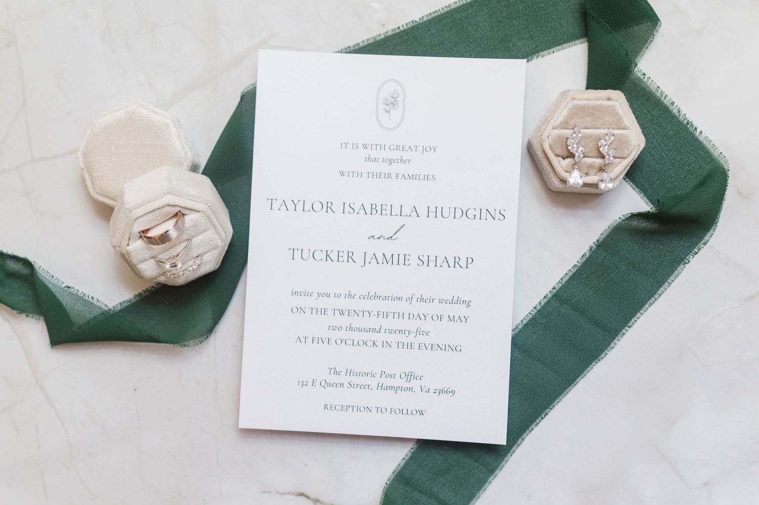 Wedding invitations and green silk ribbons styled on light background.