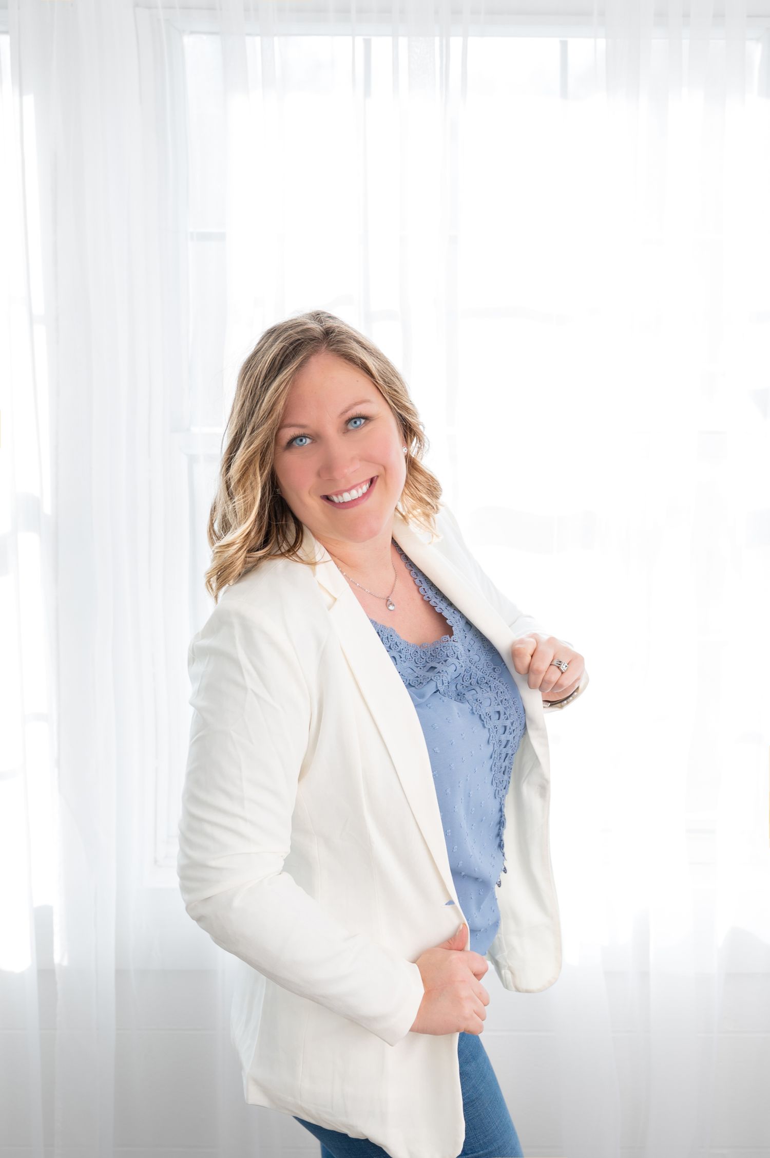 Professional portrait session with white backdrop and soft natural lighting.