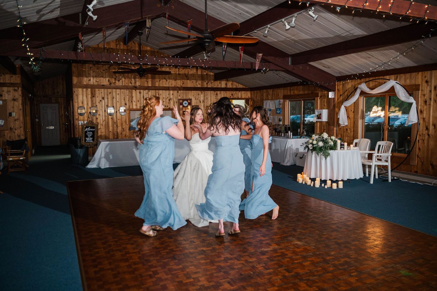 Wedding reception setup in a rustic barn venue with blue accent decorations.
