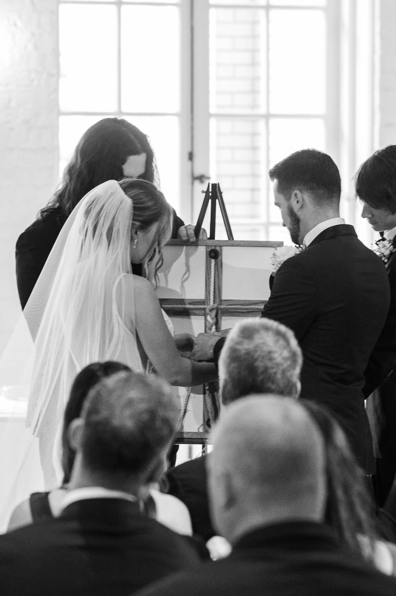Black and white photo of wedding ceremony guests watching the proceedings.