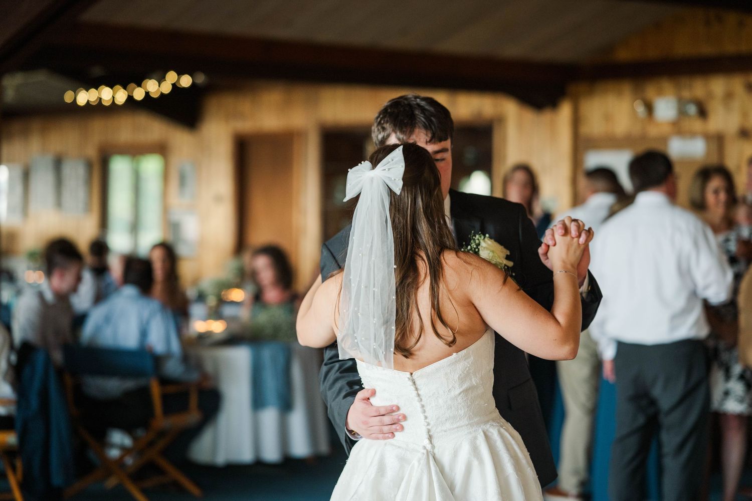 Wedding guests dancing and celebrating on the reception dance floor.