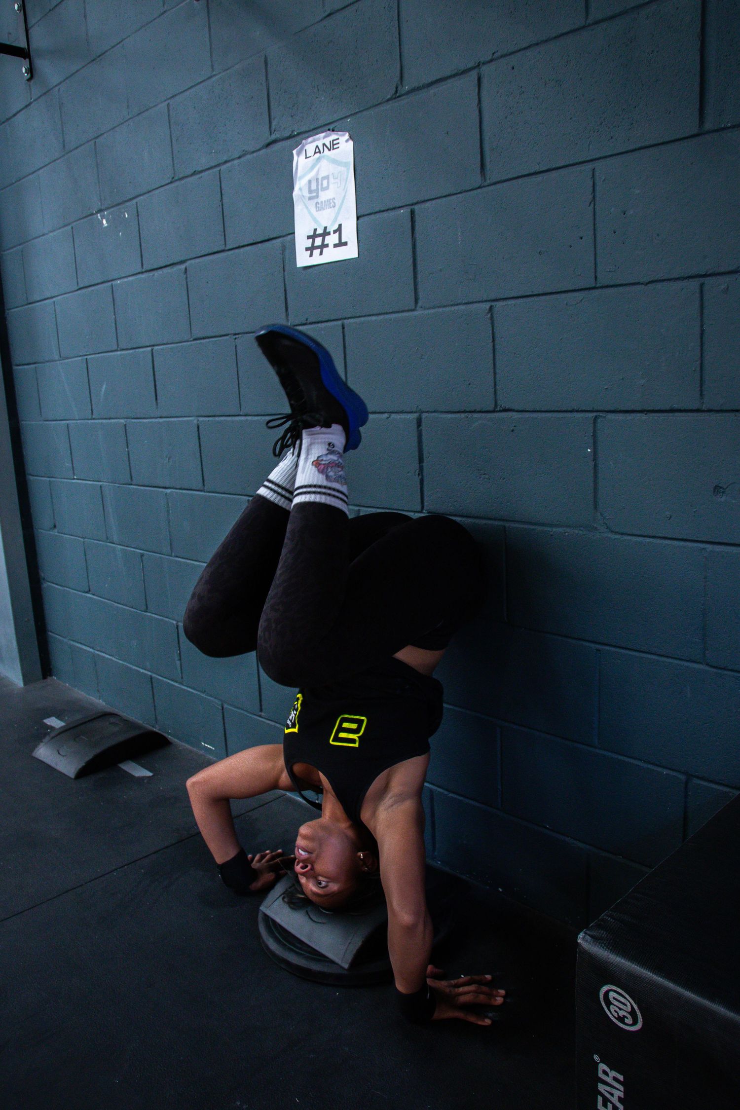 Sequential photos show dark figures crouching along a gray cinderblock wall, creating a mysterious sequence of movement.