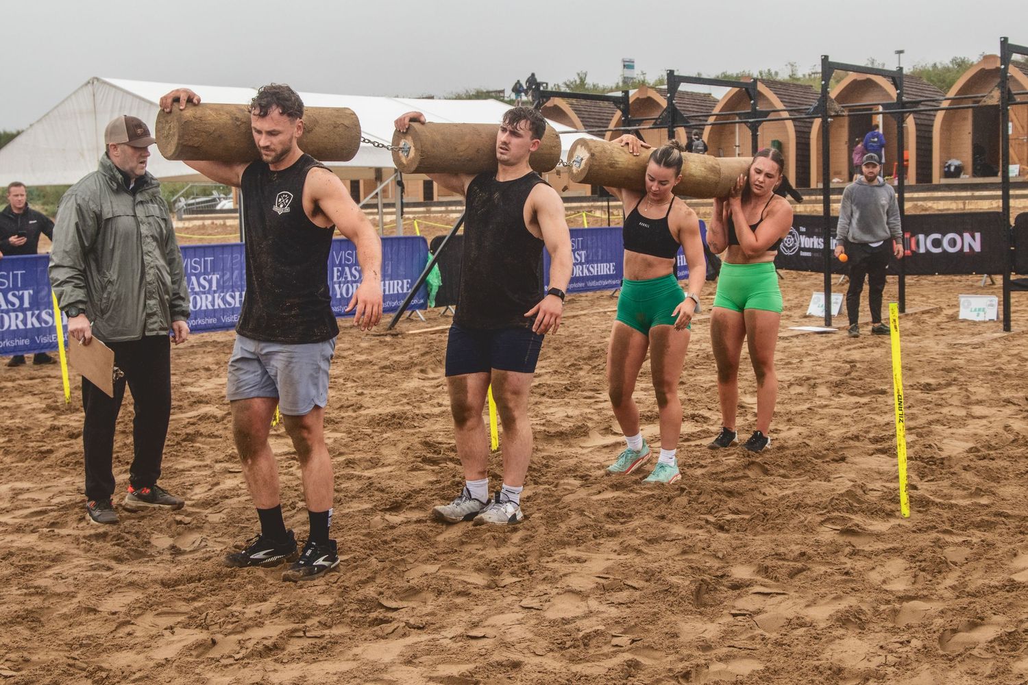 People gathered on a sandy beach court playing competitive volleyball during an outdoor tournament event.