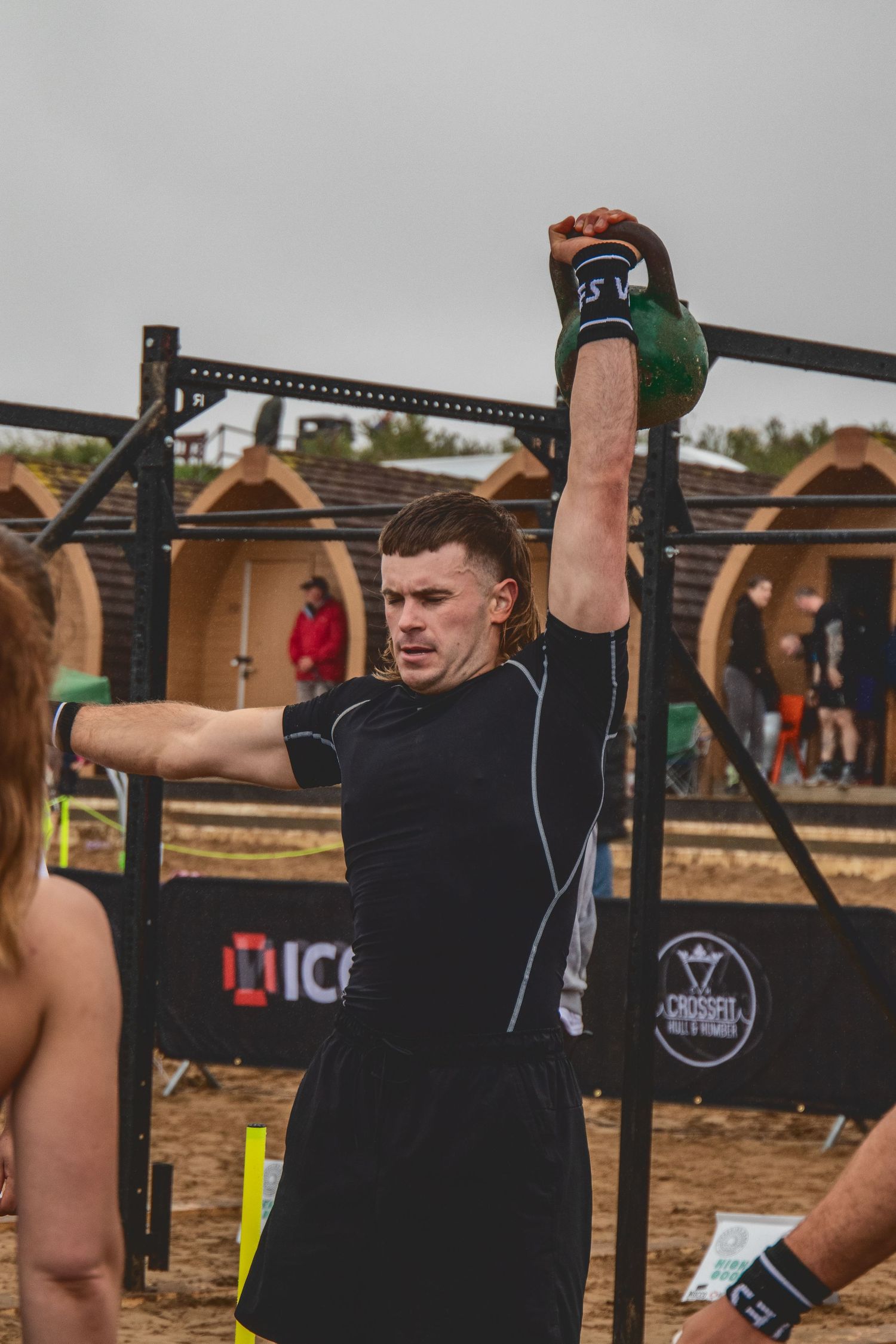 Athletes performing pull-ups on outdoor fitness equipment during an intense workout session.