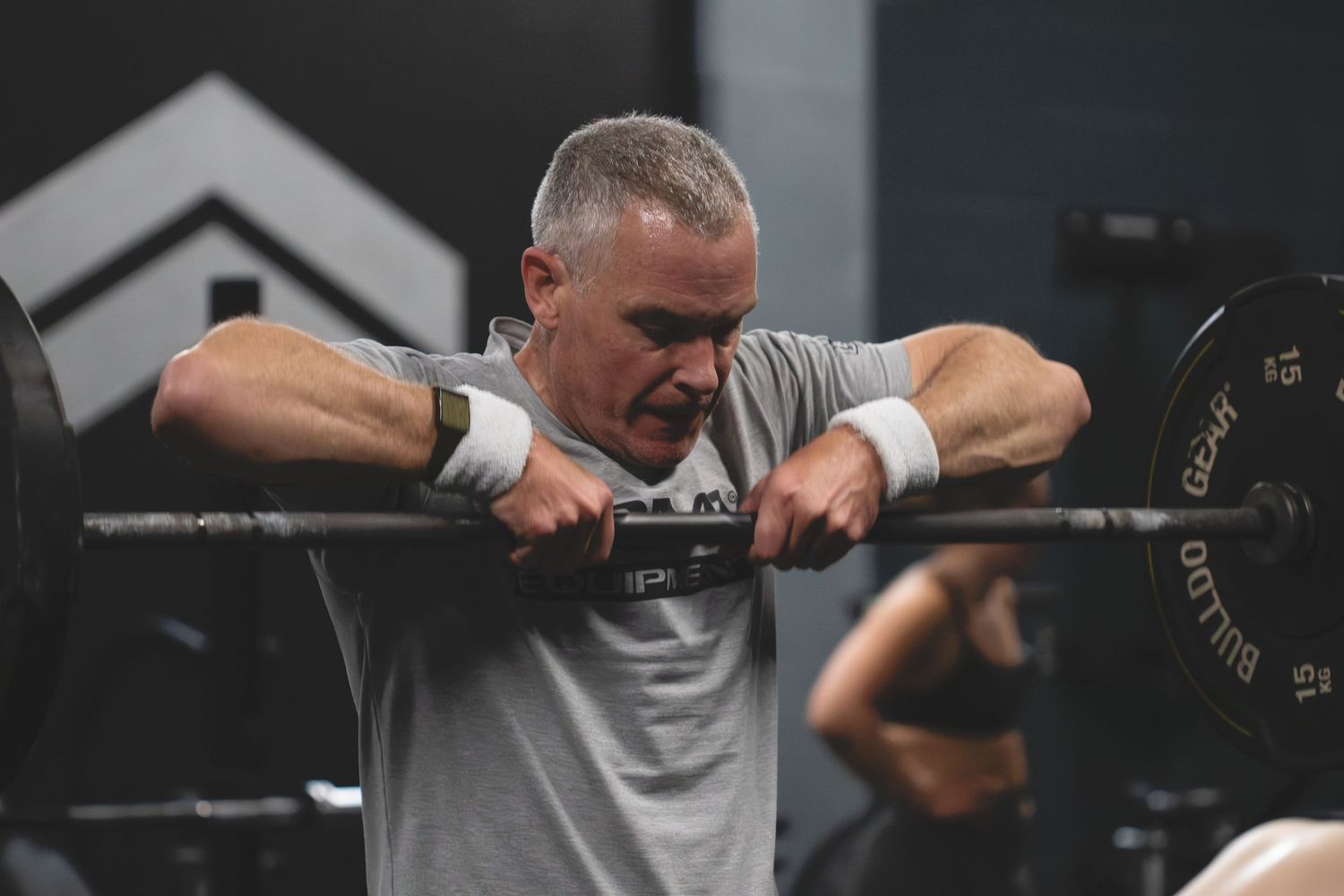 A man performs barbell bicep curls in sequence, demonstrating proper form and technique during an arm workout.