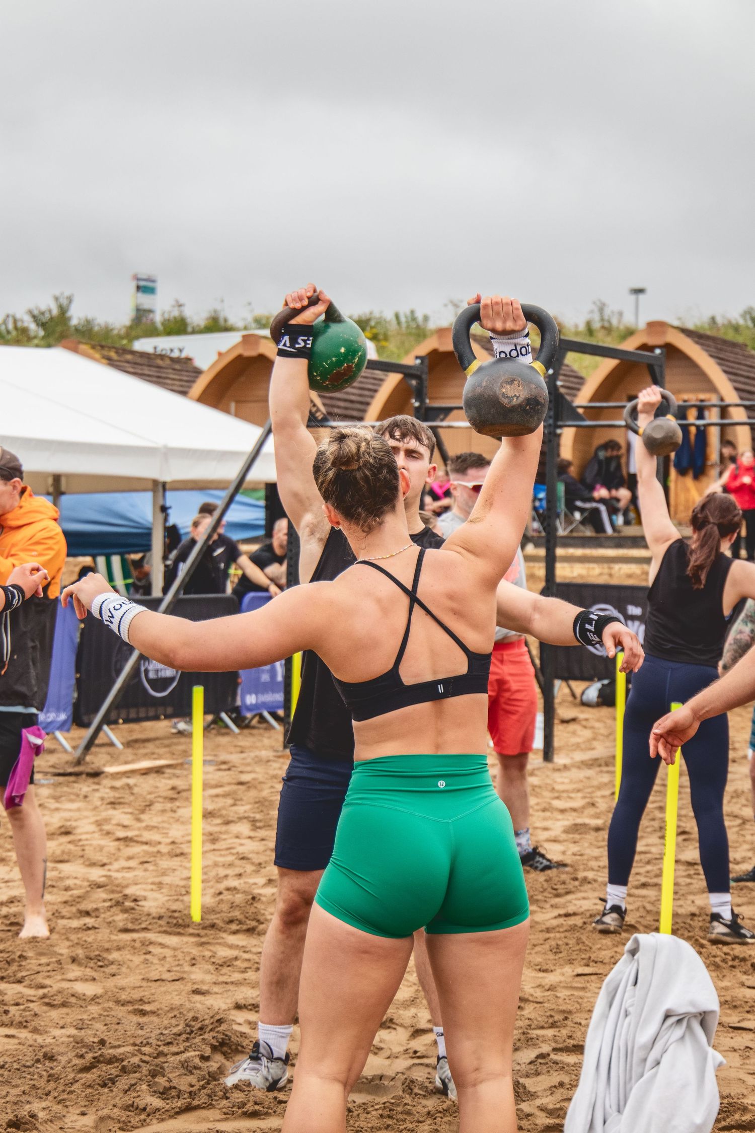 Beach volleyball players stretch and warm up together on sandy court before a match.