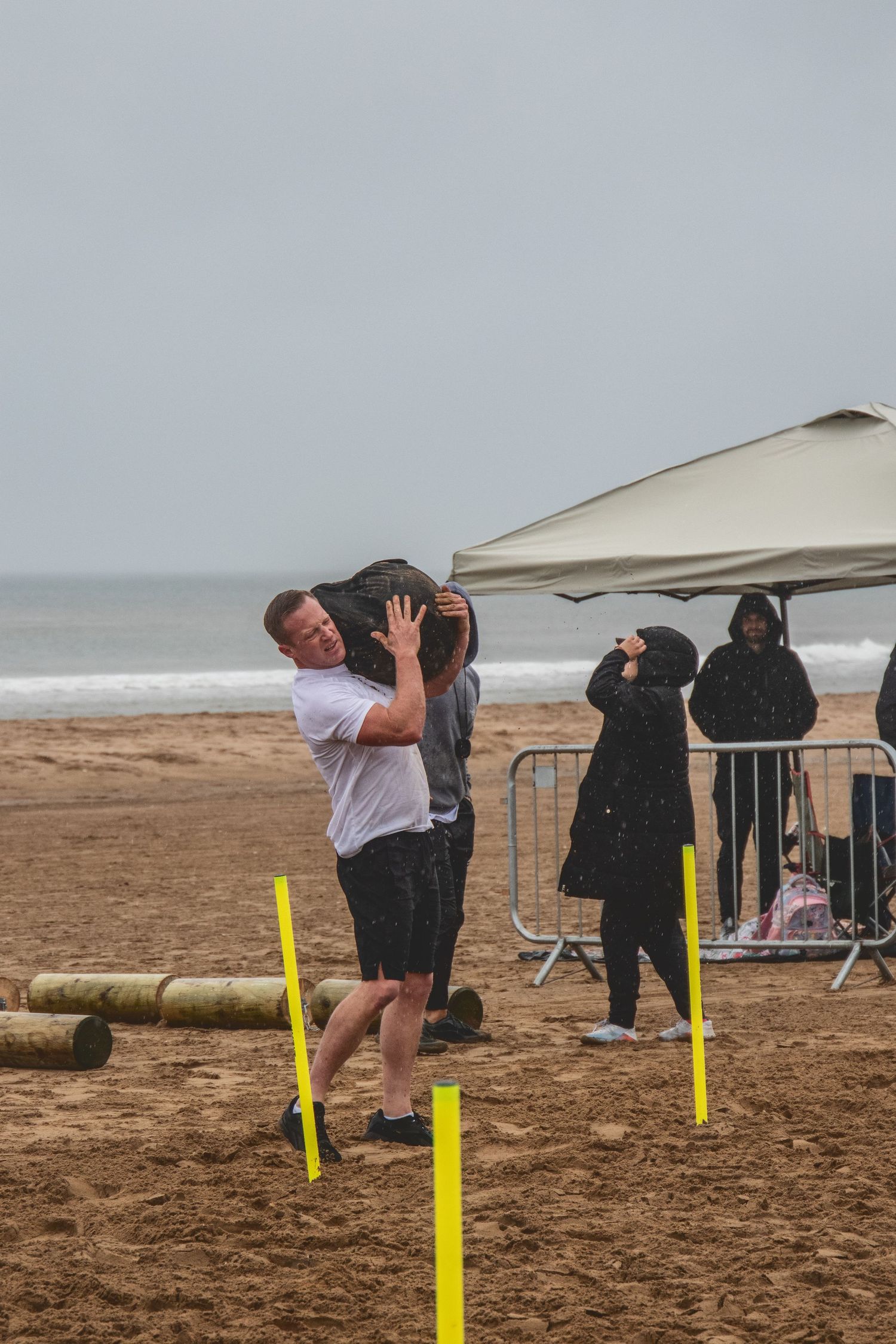 A sequence of photos showing someone practicing surfing takeoff techniques on sandy beach with yellow markers.