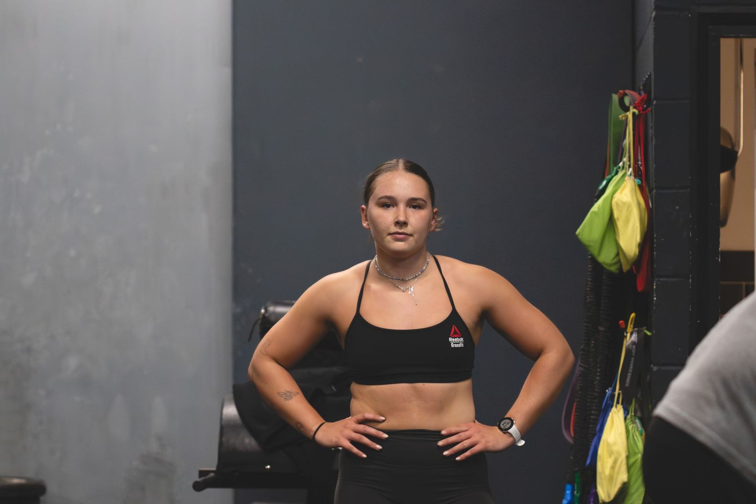 Side view image of someone doing a workout sequence on black exercise mats in a fitness studio.