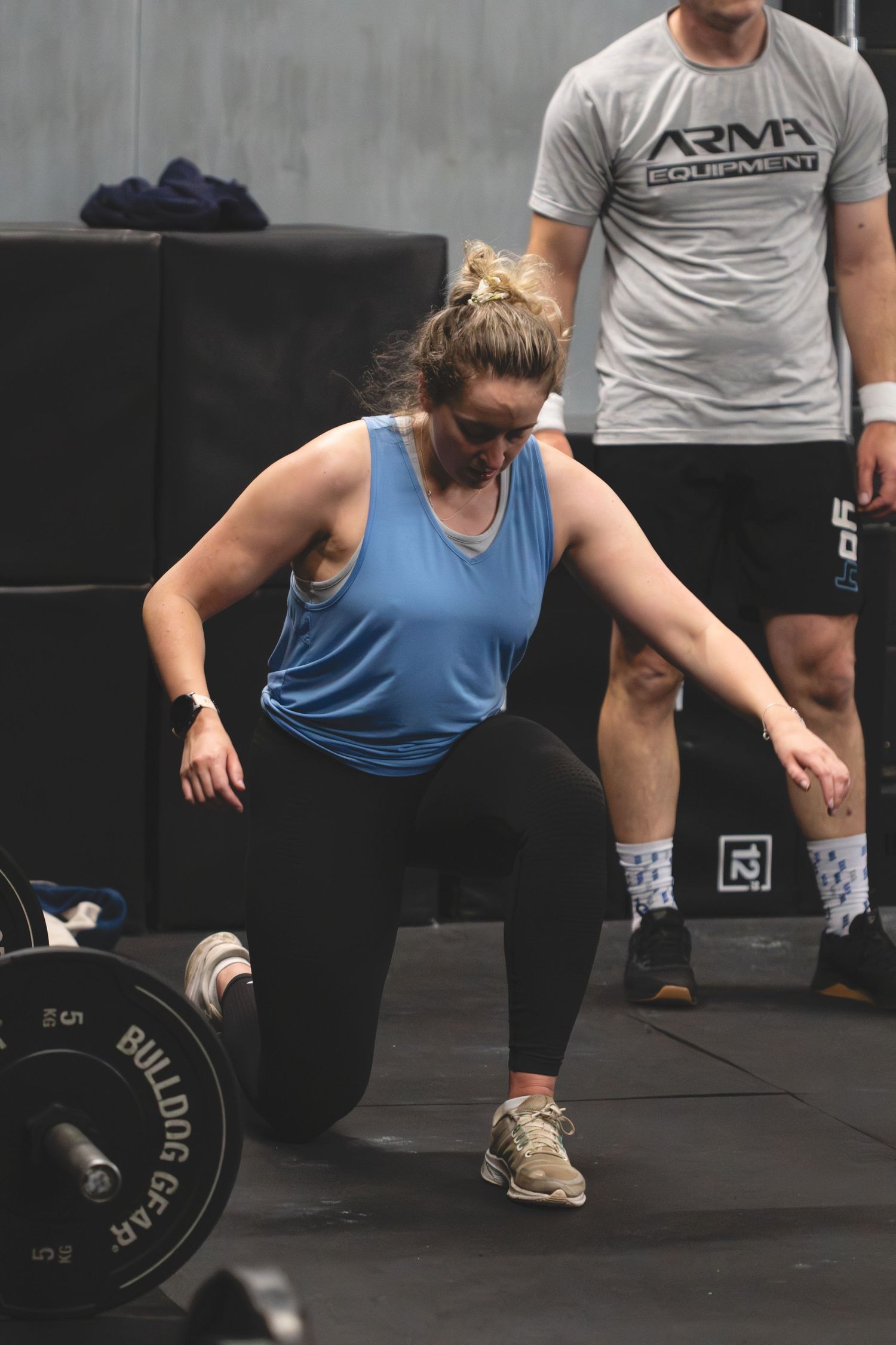 Series of weightlifting stances showing proper form for a deadlift exercise on a black gym floor.