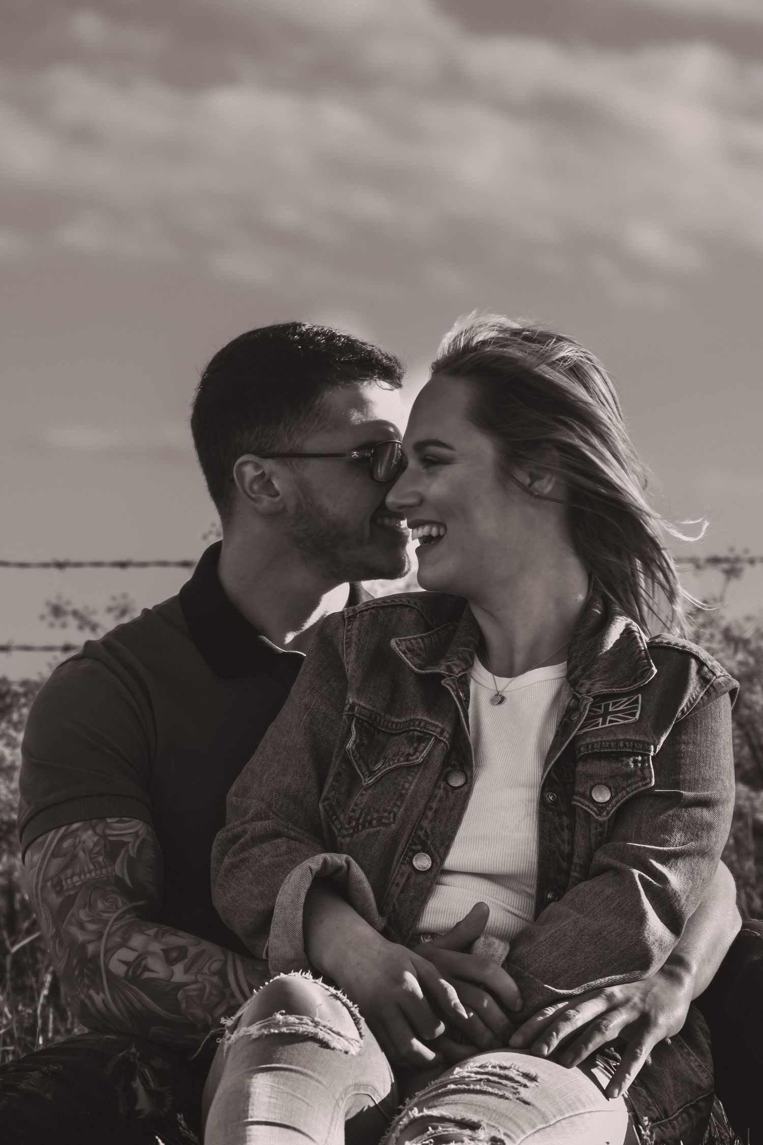 Couple in denim jackets sharing romantic moments during an outdoor photoshoot.
