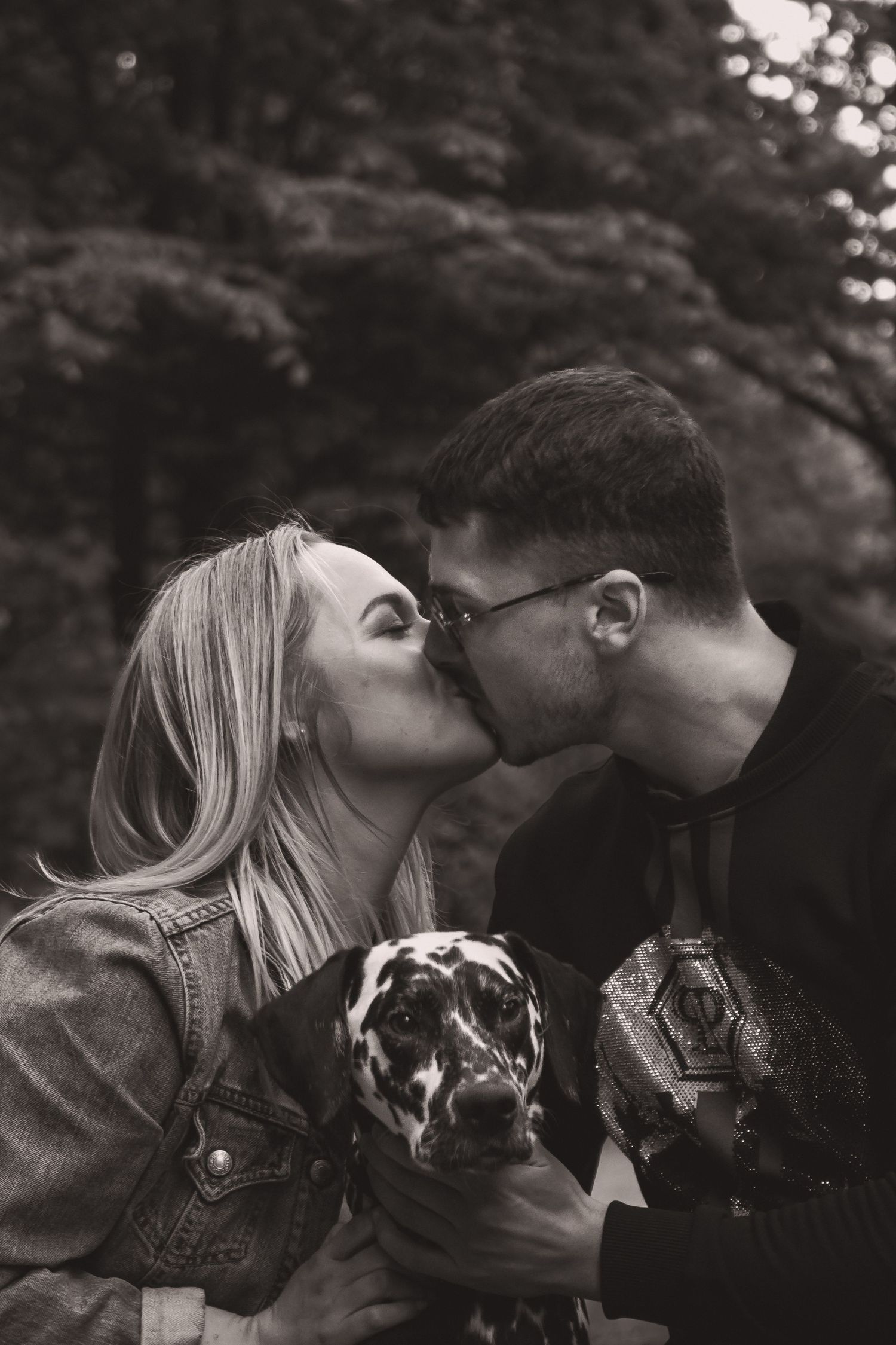 Artistic black and white close-up of couple sharing an intimate moment outdoors.
