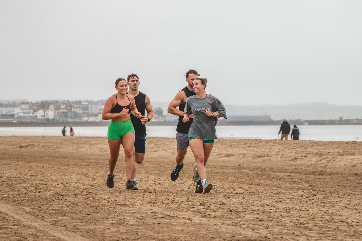 A sequence of beach running photos showing people jogging along a sandy shoreline with water in the background.