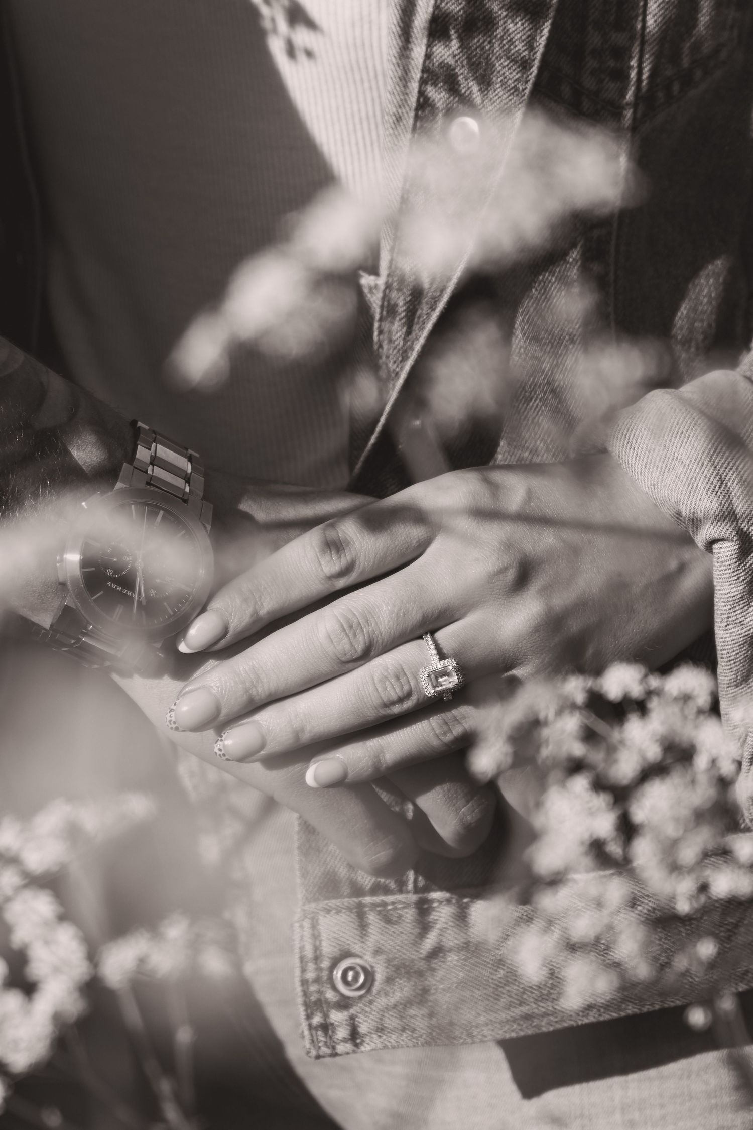 Black and white close-up of hands with rings in soft focus.