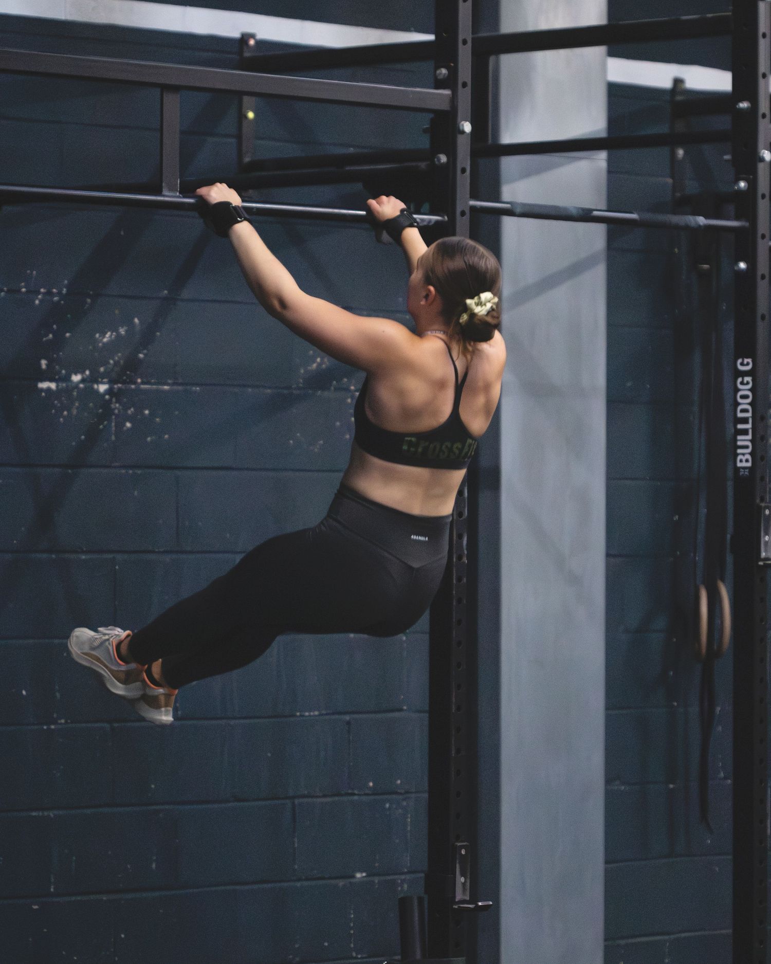 Sequence of images showing a gymnast performing a dynamic transition between horizontal bars in an indoor gym space.